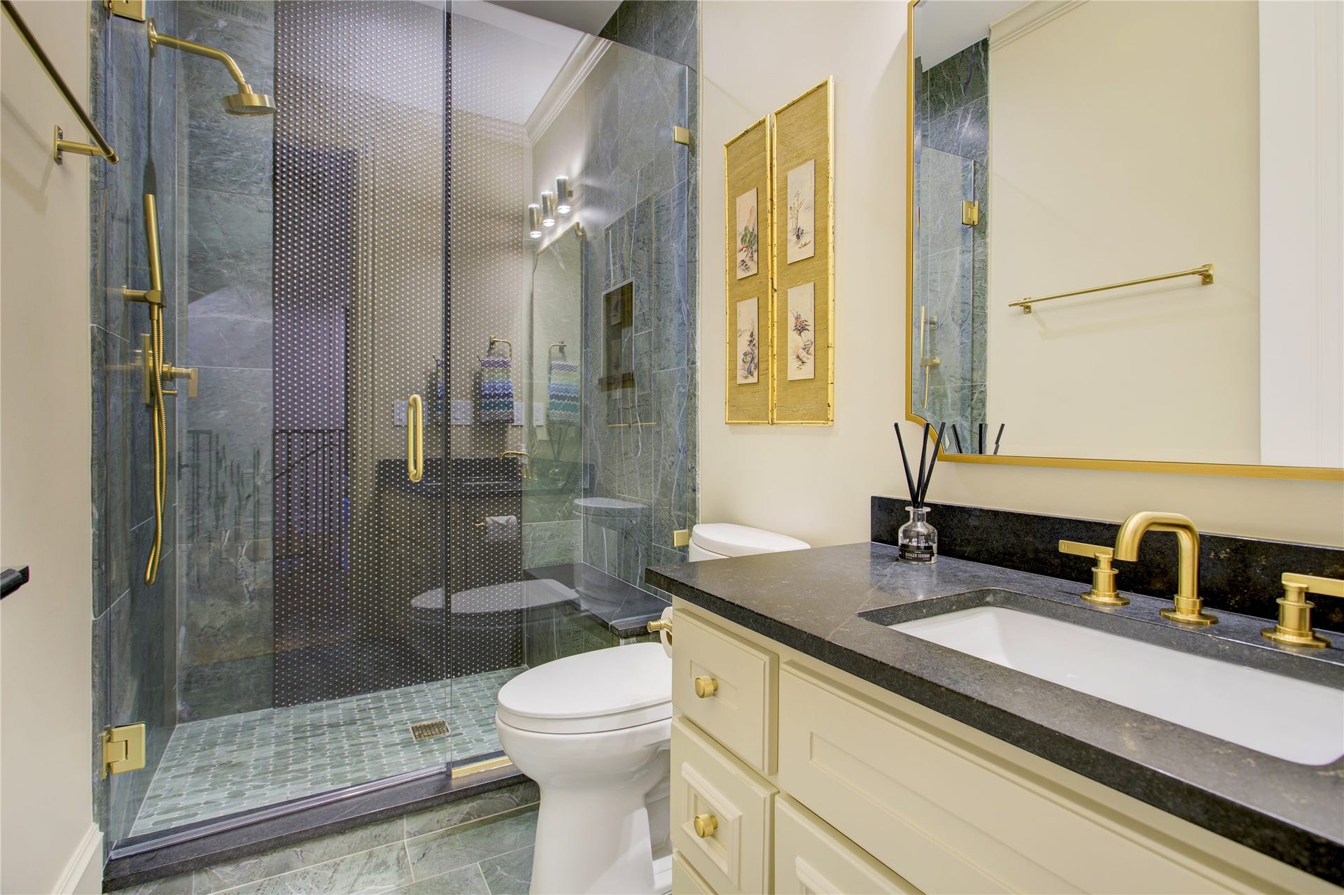 2215 North Boulevard, Houston, TX 77098 Floor-to-ceiling green stone tile pairs with black bubble accents and honed black granite countertops for a bold, sophisticated bath.