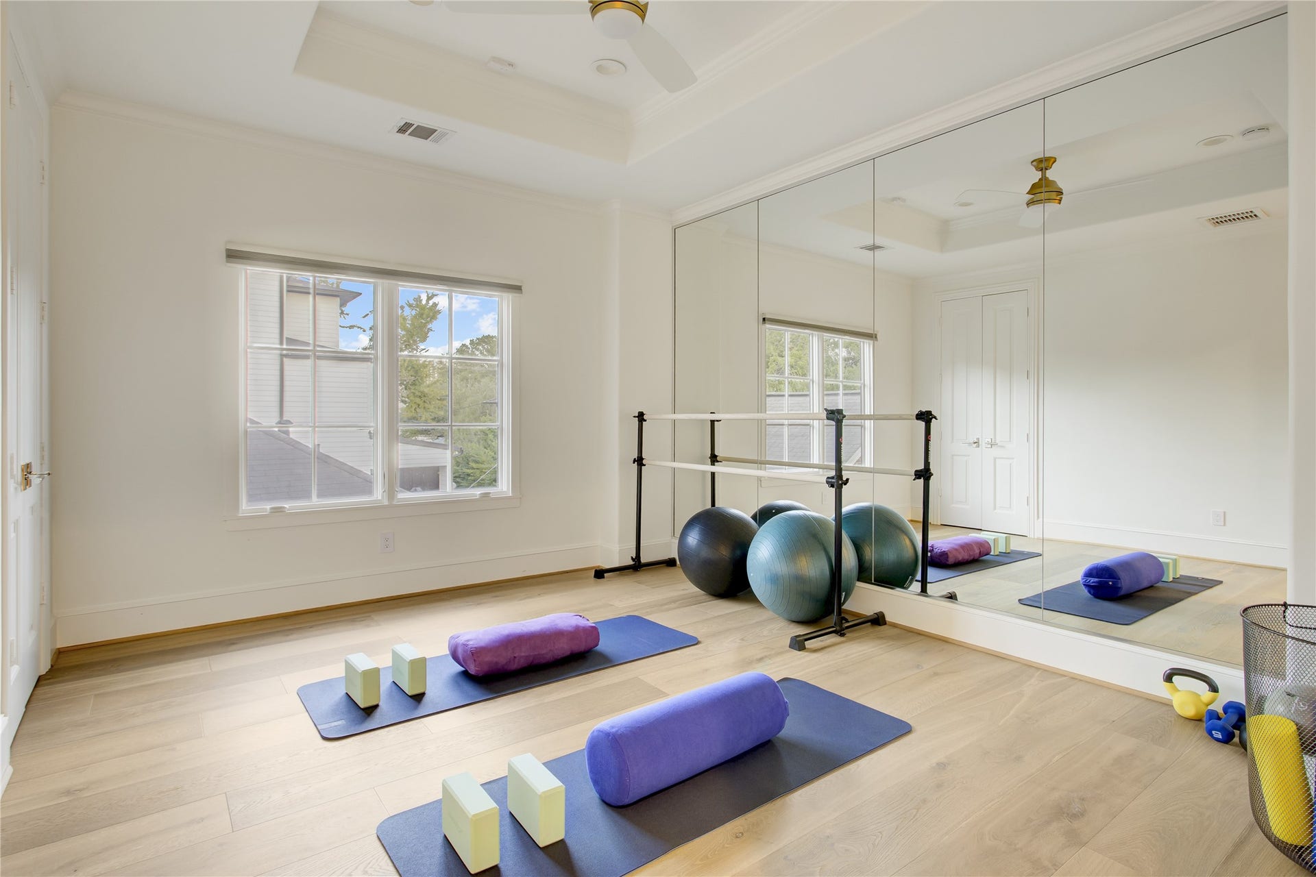 2215 North Boulevard, Houston, TX 77098 Wide-plank white oak floors and a 10-foot tray ceiling frame this flexible fourth bedroom, currently styled as a mirrored fitness studio.