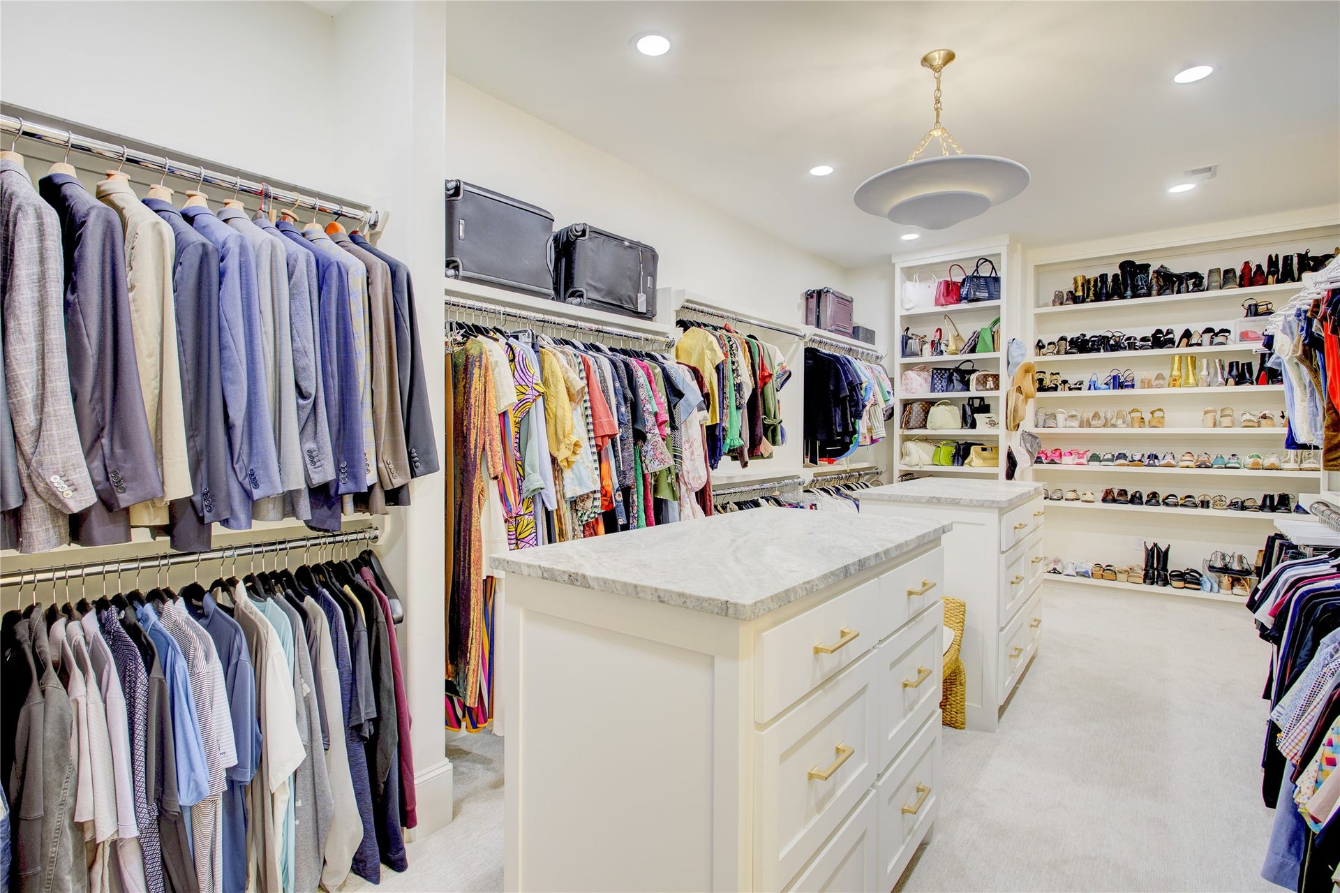 2215 North Boulevard, Houston, TX 77098 Designed like a private boutique, this primary closet features custom built-ins and dual dolomite-topped packing islands.