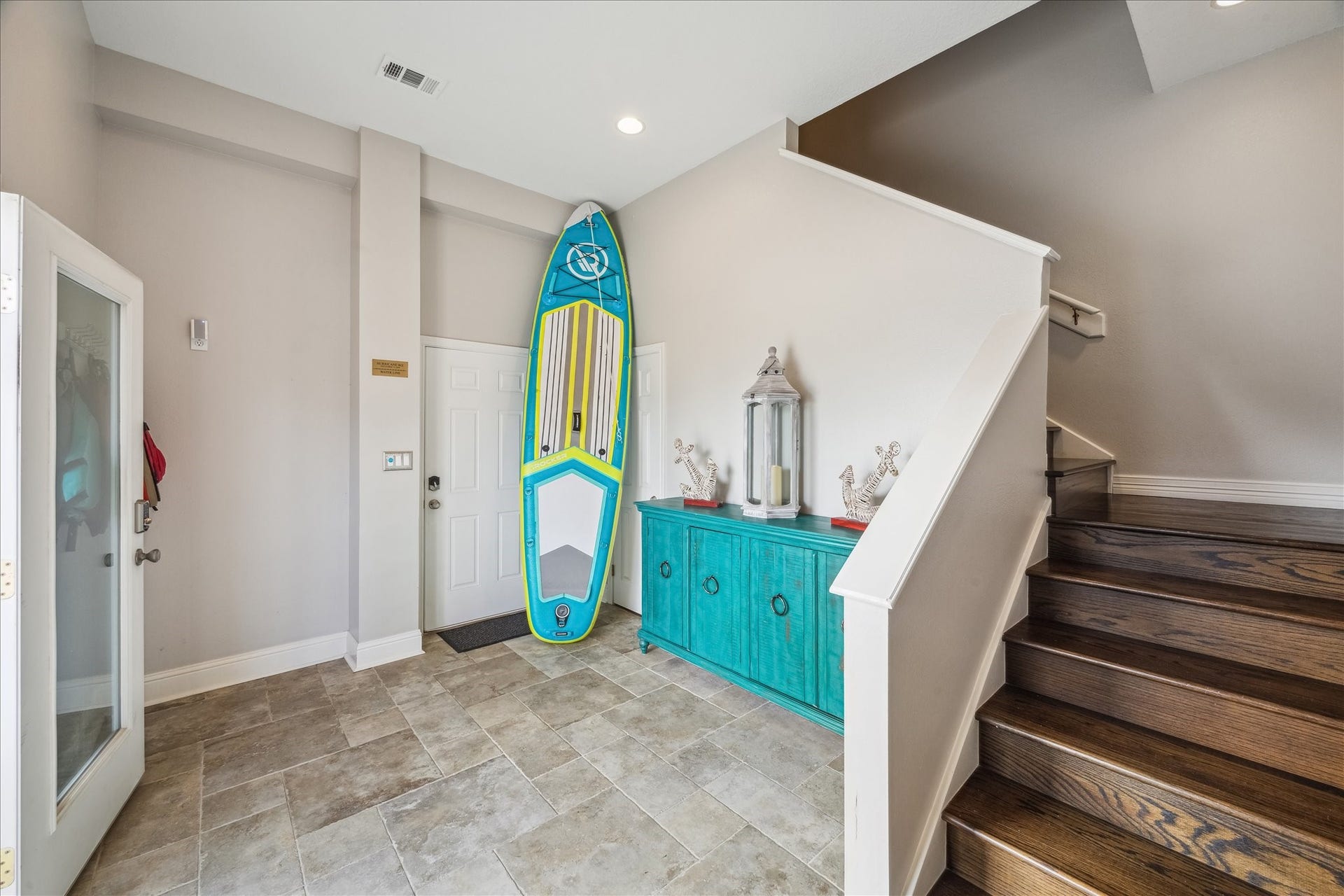 519 Westerly Drive, Tiki Island, TX 77554 Bright , welcoming entryway featuring tiled flooring and a vibrant turquoise console. Ideal for welcoming guests with style.