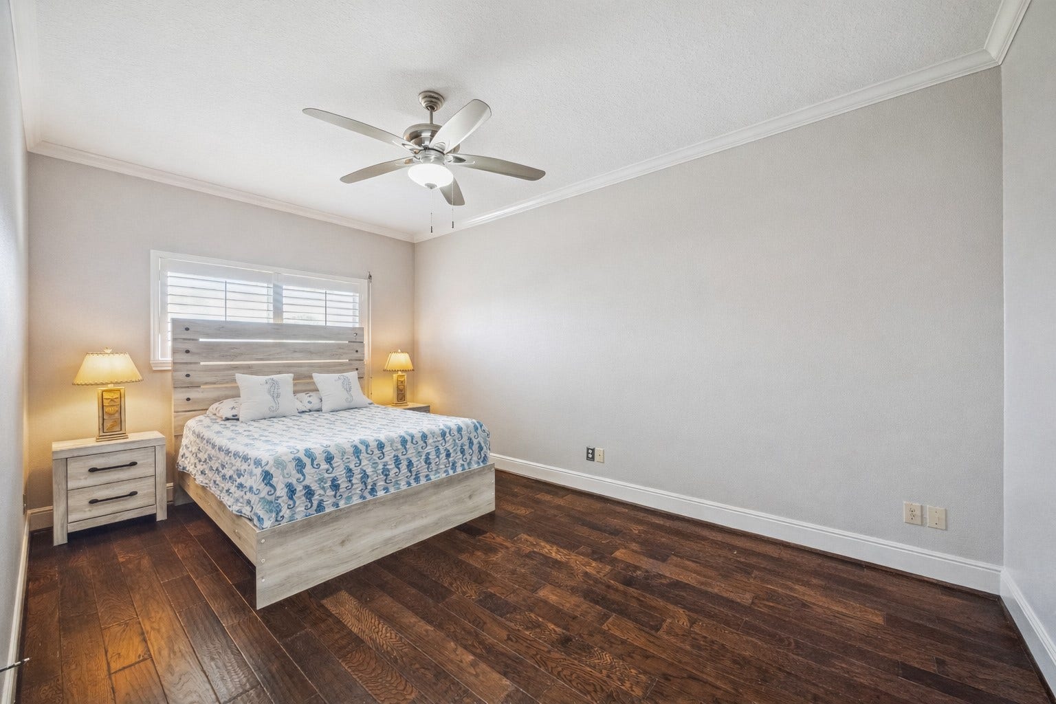519 Westerly Drive, Tiki Island, TX 77554 This secondary bedroom features hardwood floors, a modern ceiling fan, and soft lighting. Neutral walls create a relaxing atmosphere.