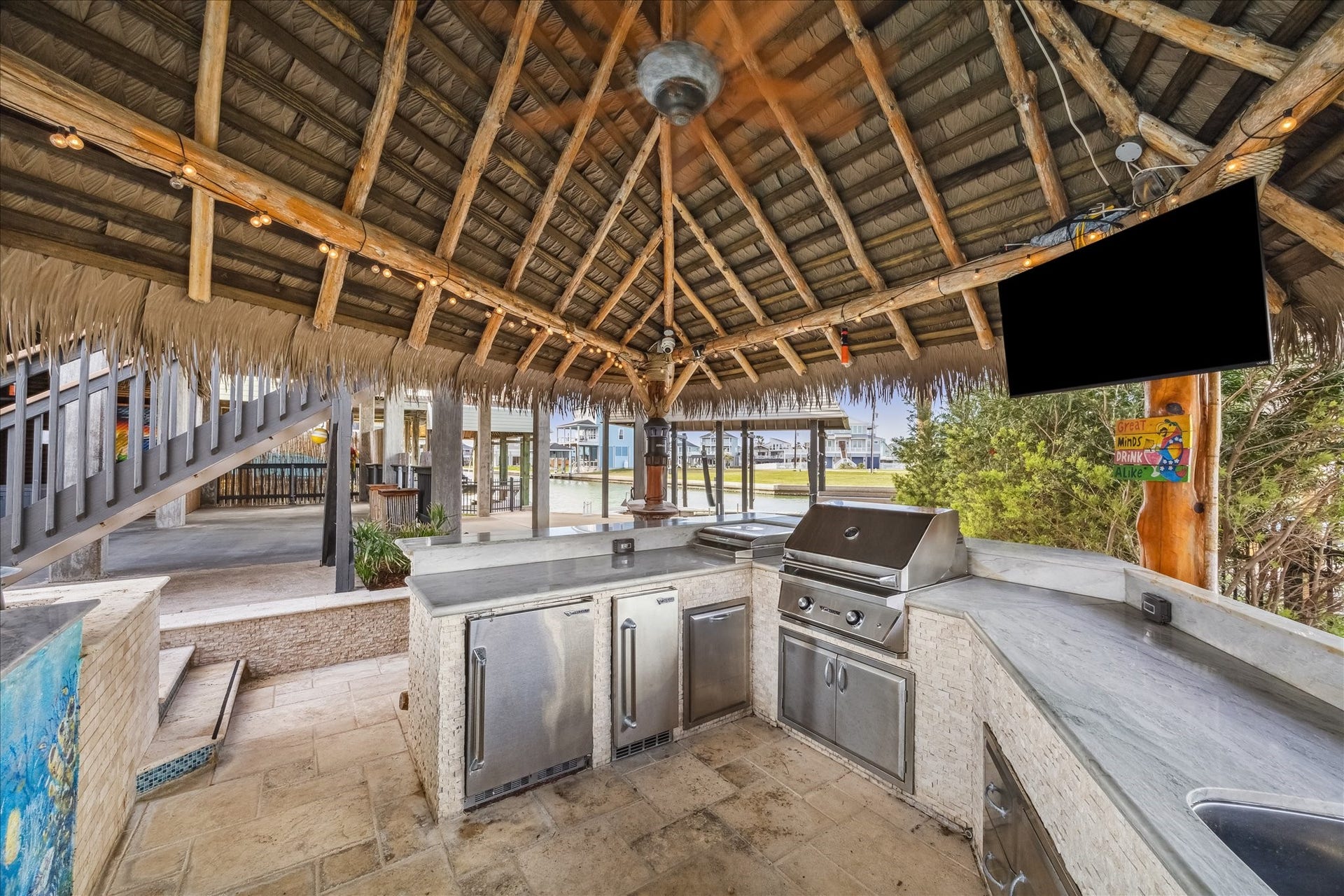 519 Westerly Drive, Tiki Island, TX 77554 The outdoor kitchen features stainless steel appliances, a grill, and ample counter space. It offers a relaxed, tropical ambiance perfect for entertaining.