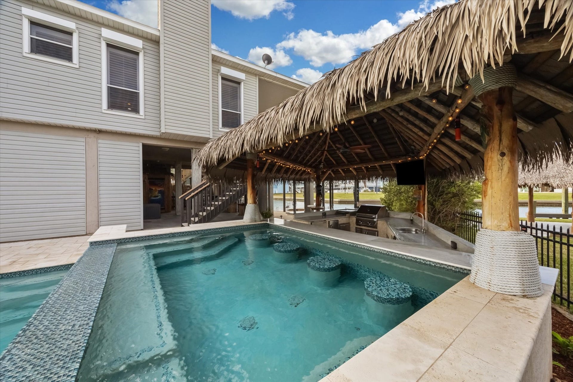 519 Westerly Drive, Tiki Island, TX 77554 The cabana includes a built-in bar and grill area, perfect for entertaining. The setting offers a resort-like feel.