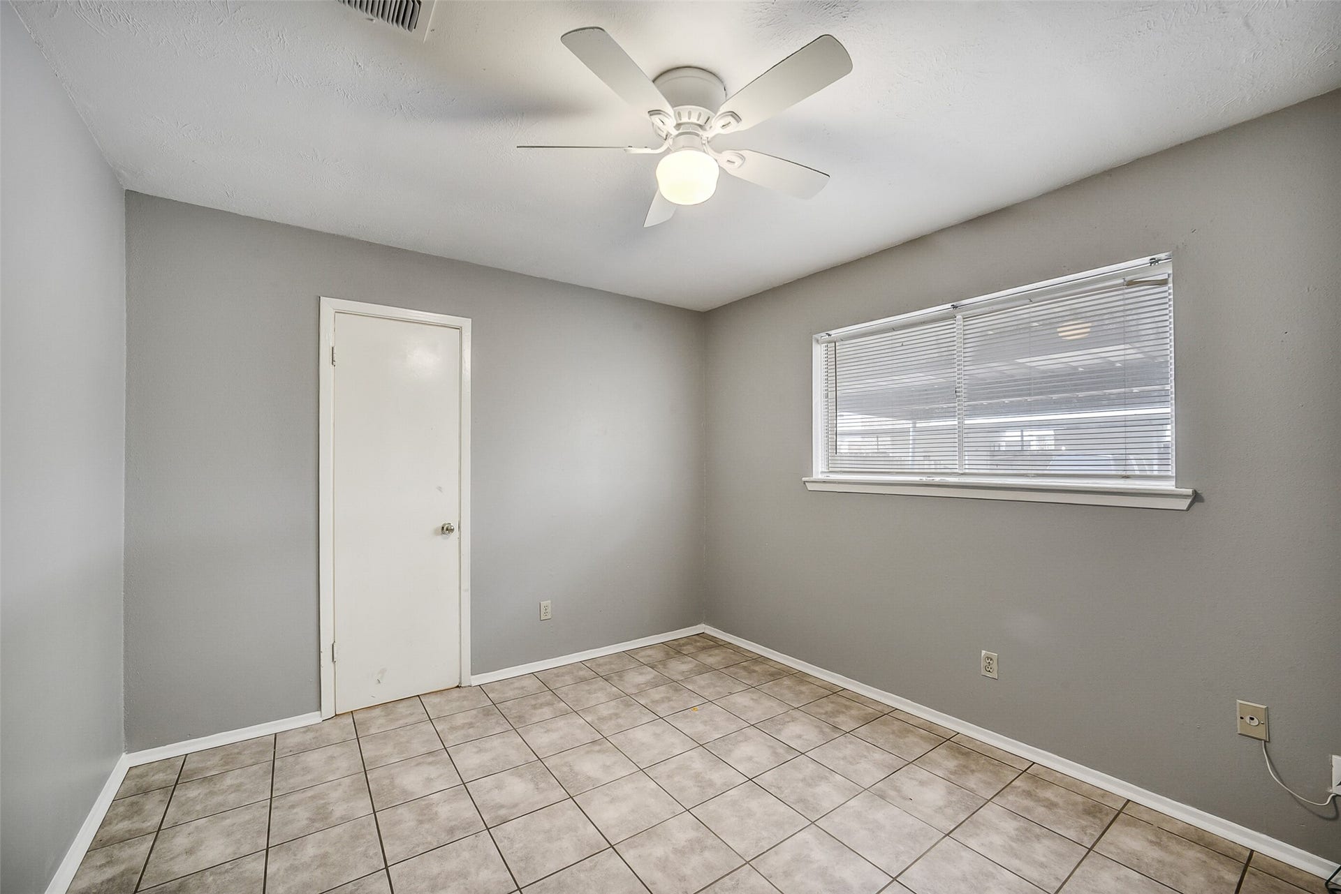 7265 Chasewood Drive, Houston, TX 77489 This comfortable secondary bedroom offers durable tile flooring, neutral paint, a ceiling fan, and a large window that fills the space with natural light. Whether used as a guest room, home office, or hobby space, it provides flexibility to fit your lifestyle.