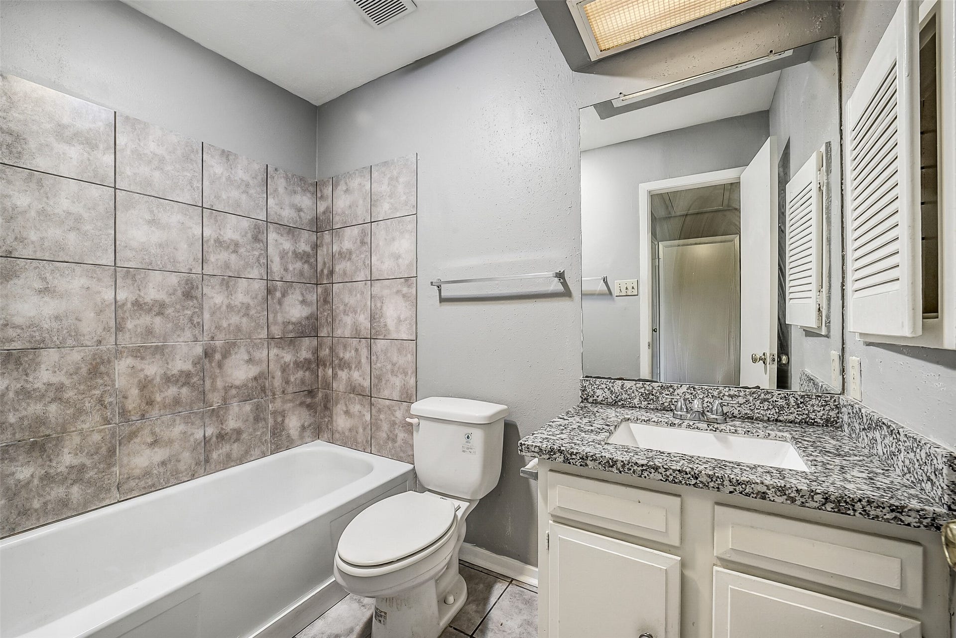 7265 Chasewood Drive, Houston, TX 77489 Conveniently located for guests and the secondary bedroom, the updated hall bath features a granite vanity, painted cabinetry, and a tub/shower combination with an oversized tile surround. Neutral finishes create a clean, timeless look that's ready for everyday use.