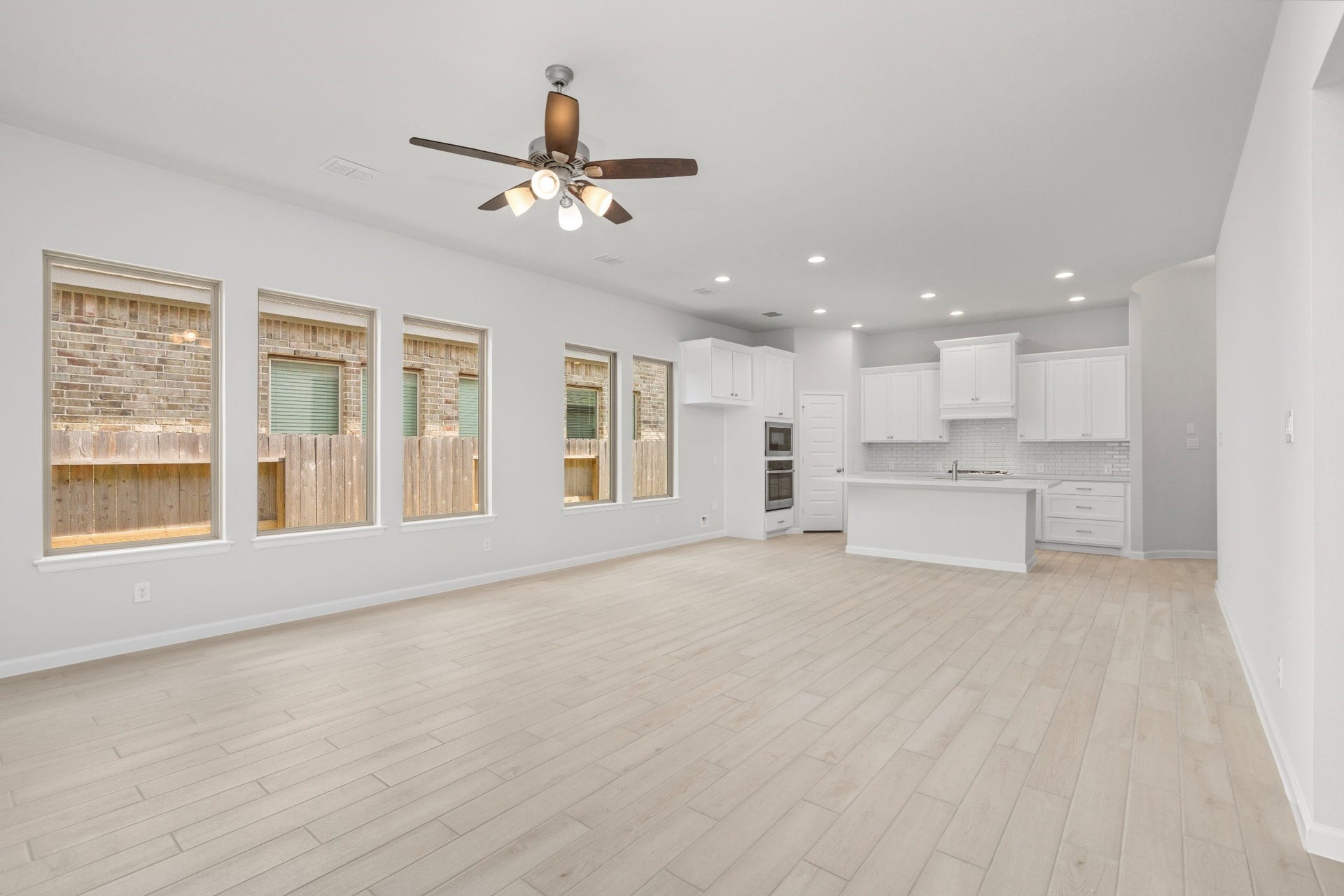 16955 Chapel Knox Drive, Humble, TX 77346 Bright open-concept living room and kitchen with wood-look tile flooring and modern finishes.