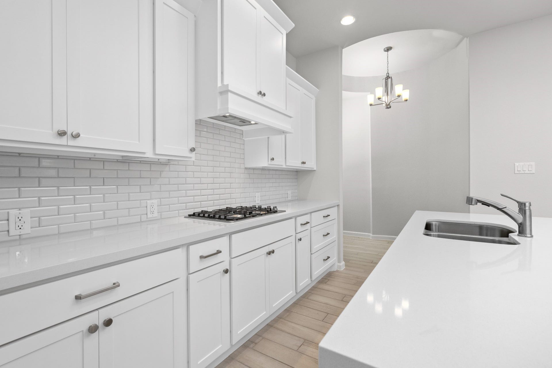 16955 Chapel Knox Drive, Humble, TX 77346 White kitchen with gas cooktop, tile backsplash, abundant cabinetry and counter space.