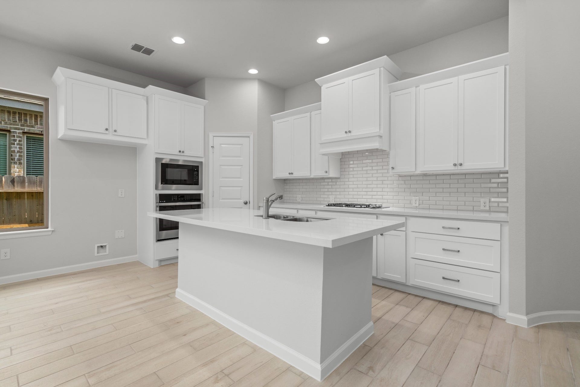16955 Chapel Knox Drive, Humble, TX 77346 Modern kitchen featuring a large center island, white cabinetry, recessed lighting and generous workspace.