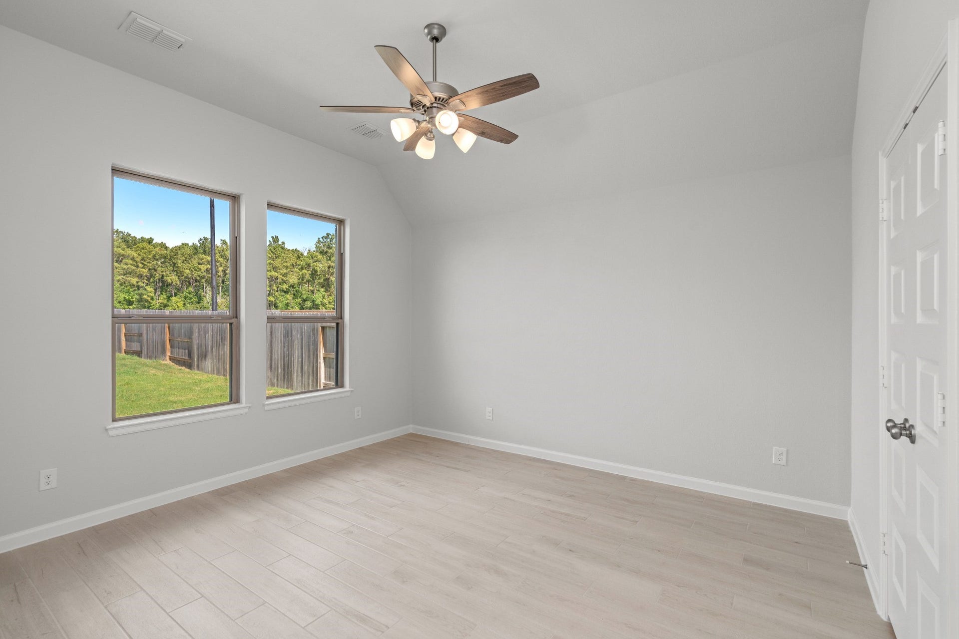16955 Chapel Knox Drive, Humble, TX 77346 Primary bedroom with large windows overlooking the fenced backyard.