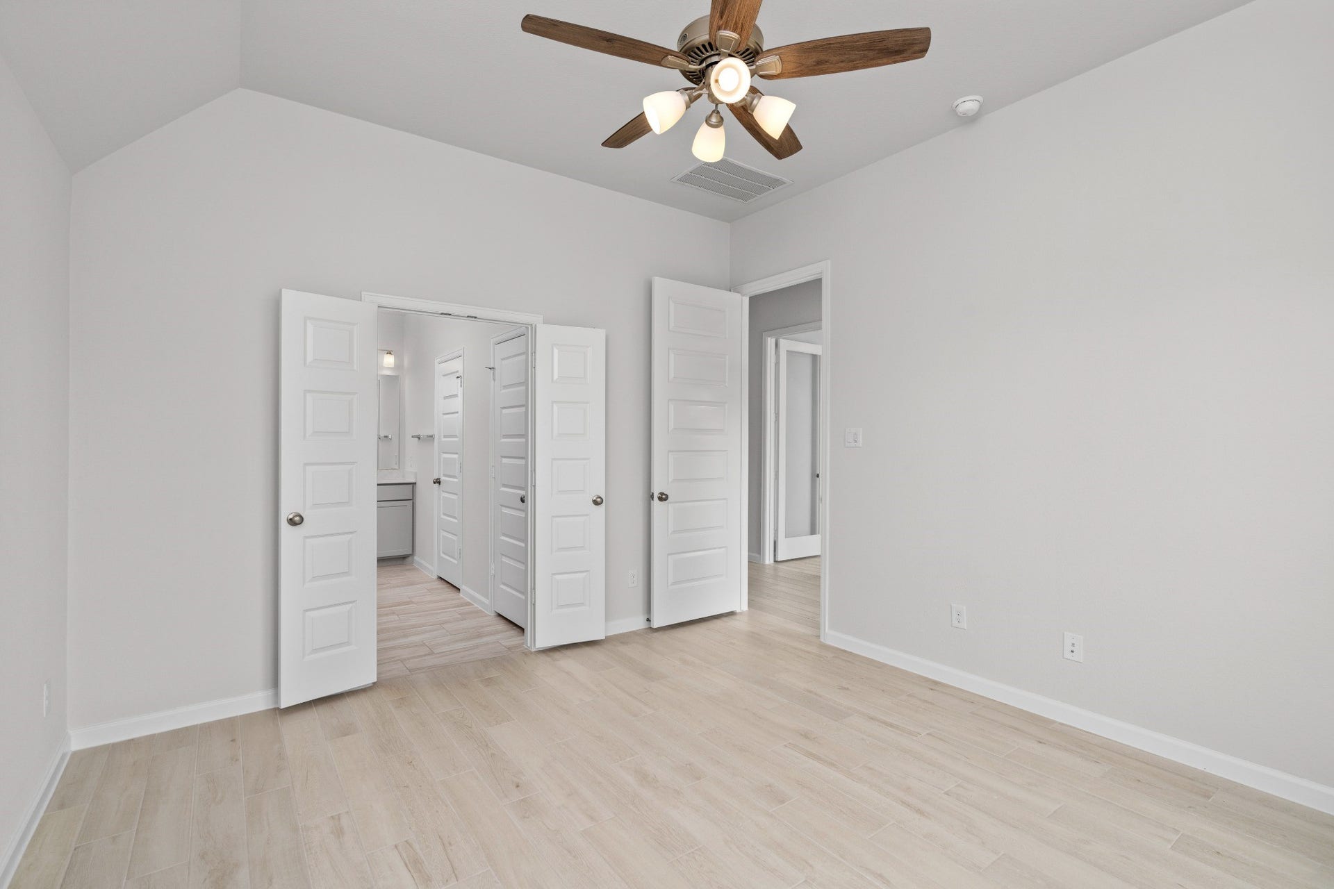 16955 Chapel Knox Drive, Humble, TX 77346 Primary bedroom suite with ceiling fan, wood-look tile flooring and private bath access.