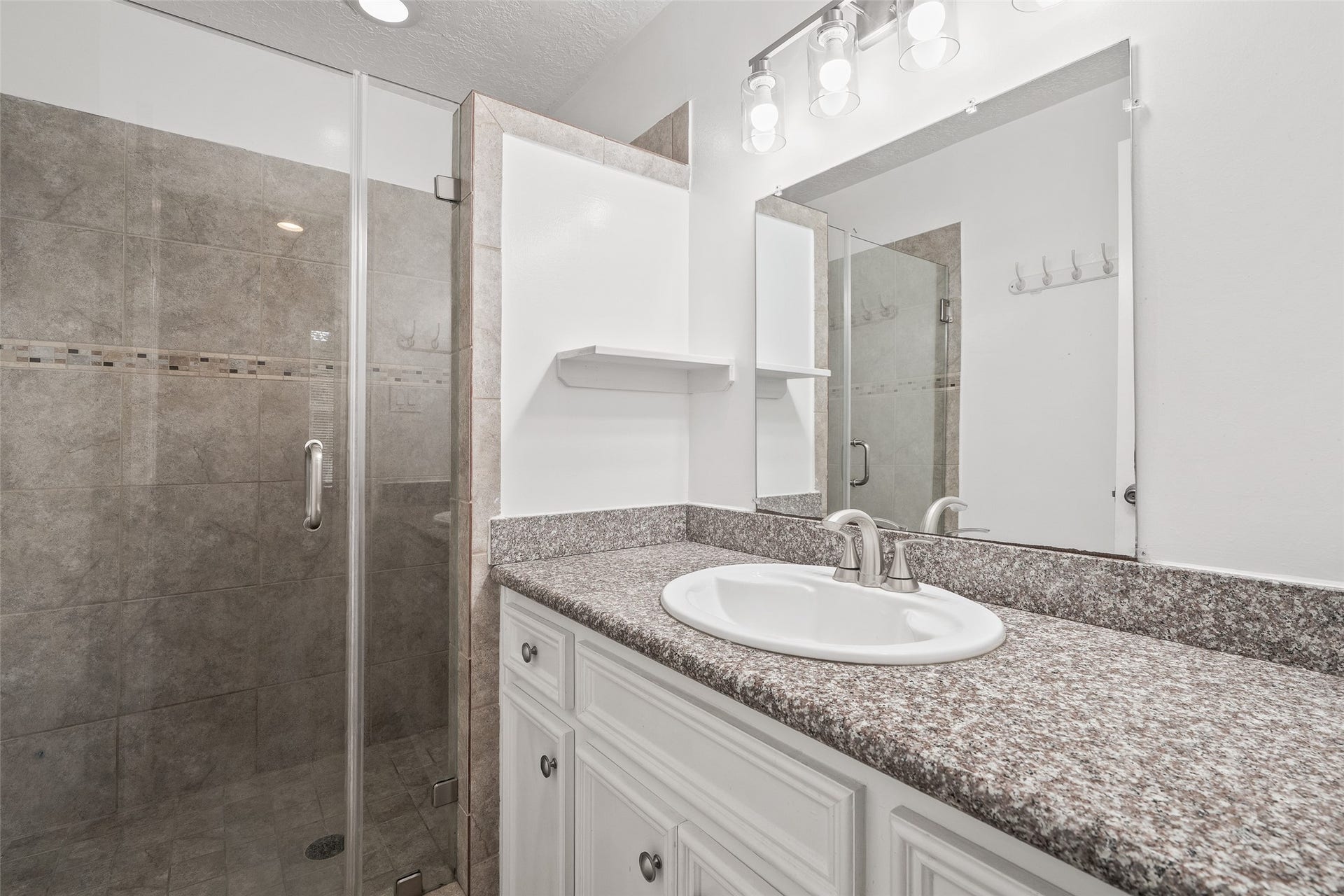 Garage apartment features a full bathroom with walk-in shower and spacious vanity.