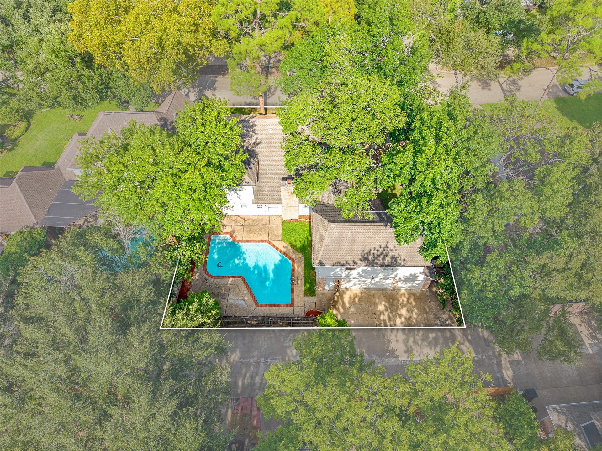 Charming home nestled among lush trees, featuring a spacious backyard with a refreshing pool, perfect for outdoor relaxation and entertainment.