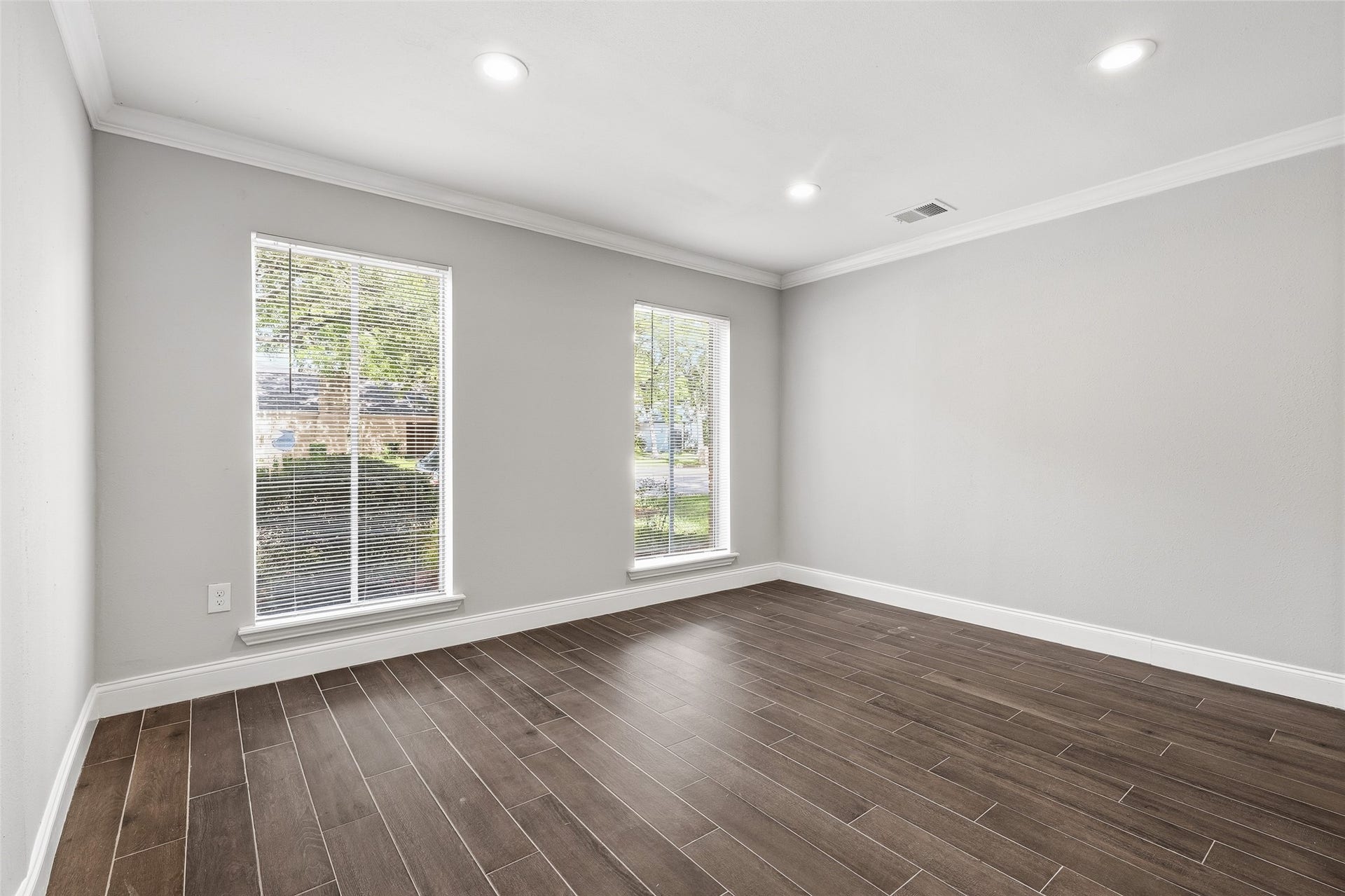 Bright and airy room with neutral gray walls, and large windows offering abundant natural light.
