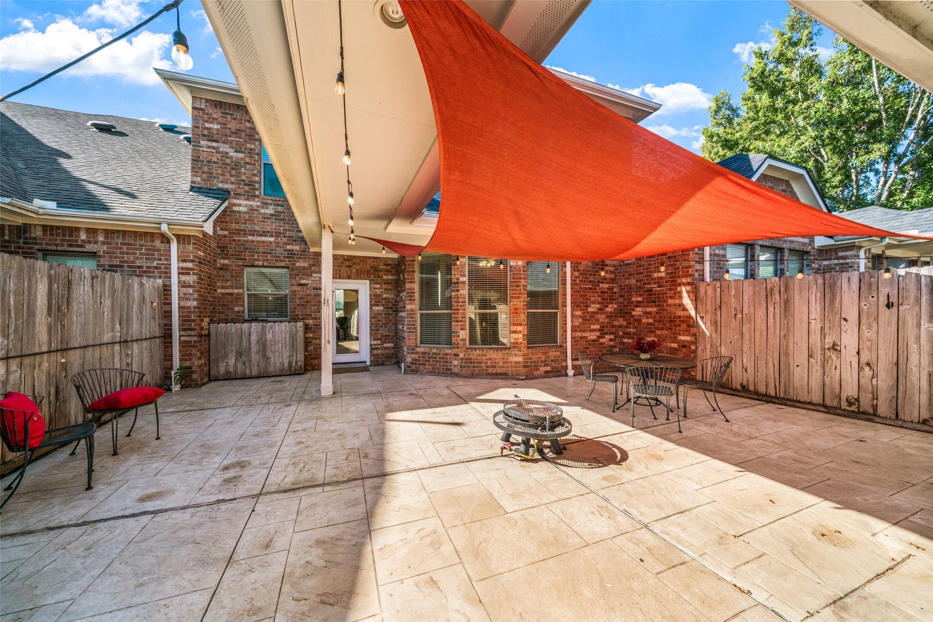 Backyard patio has been covered in beautiful stone for easy maintenance and includes a built-in gas firepit.  Great place to entertain your guests!