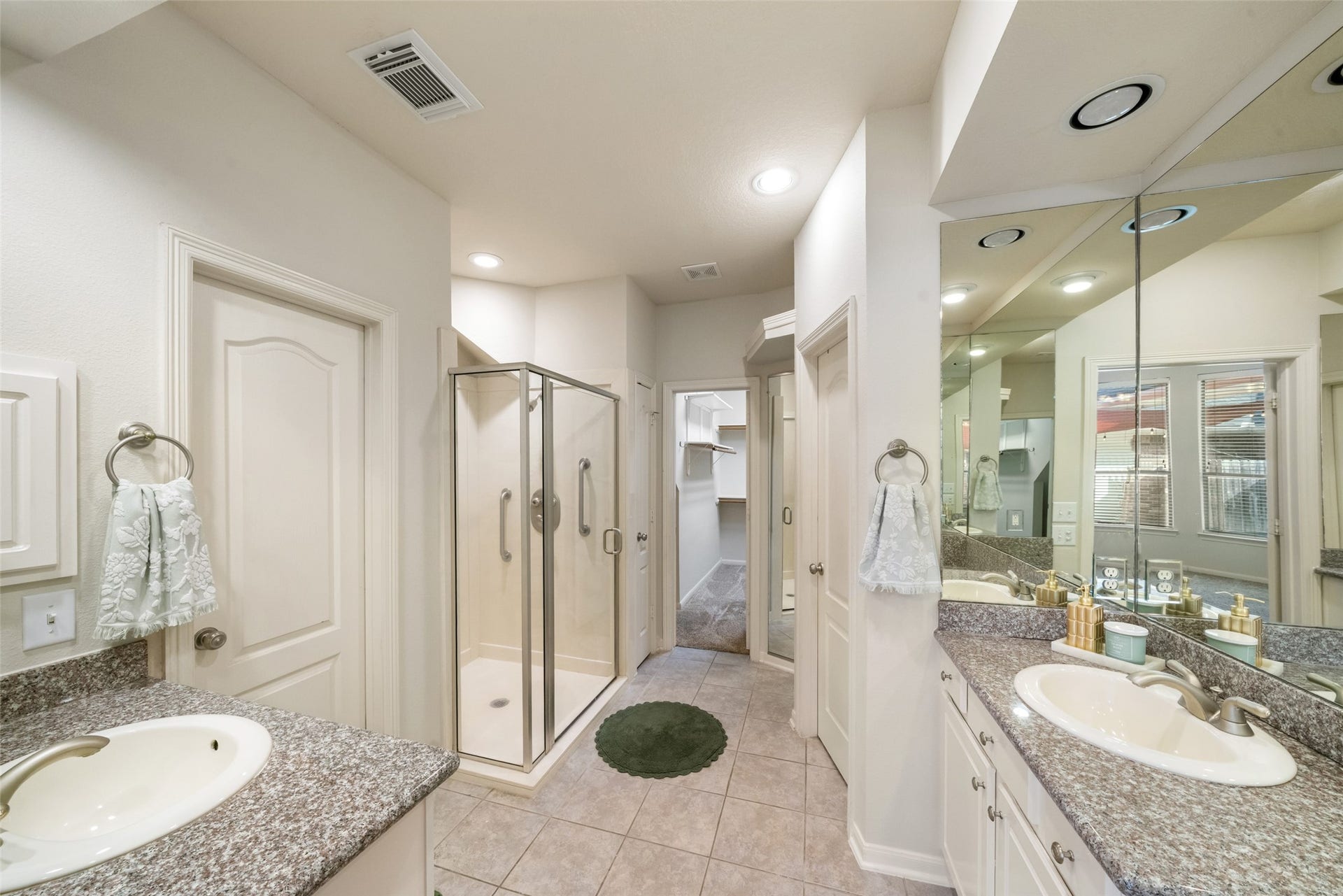 Primary bathroom is SPACIOUS.  Double sinks, double cabinets, double closets, and an oversized shower.  This room even has a floor to ceiling built-in alcove of mirrors.  Great place to get ready for the day!