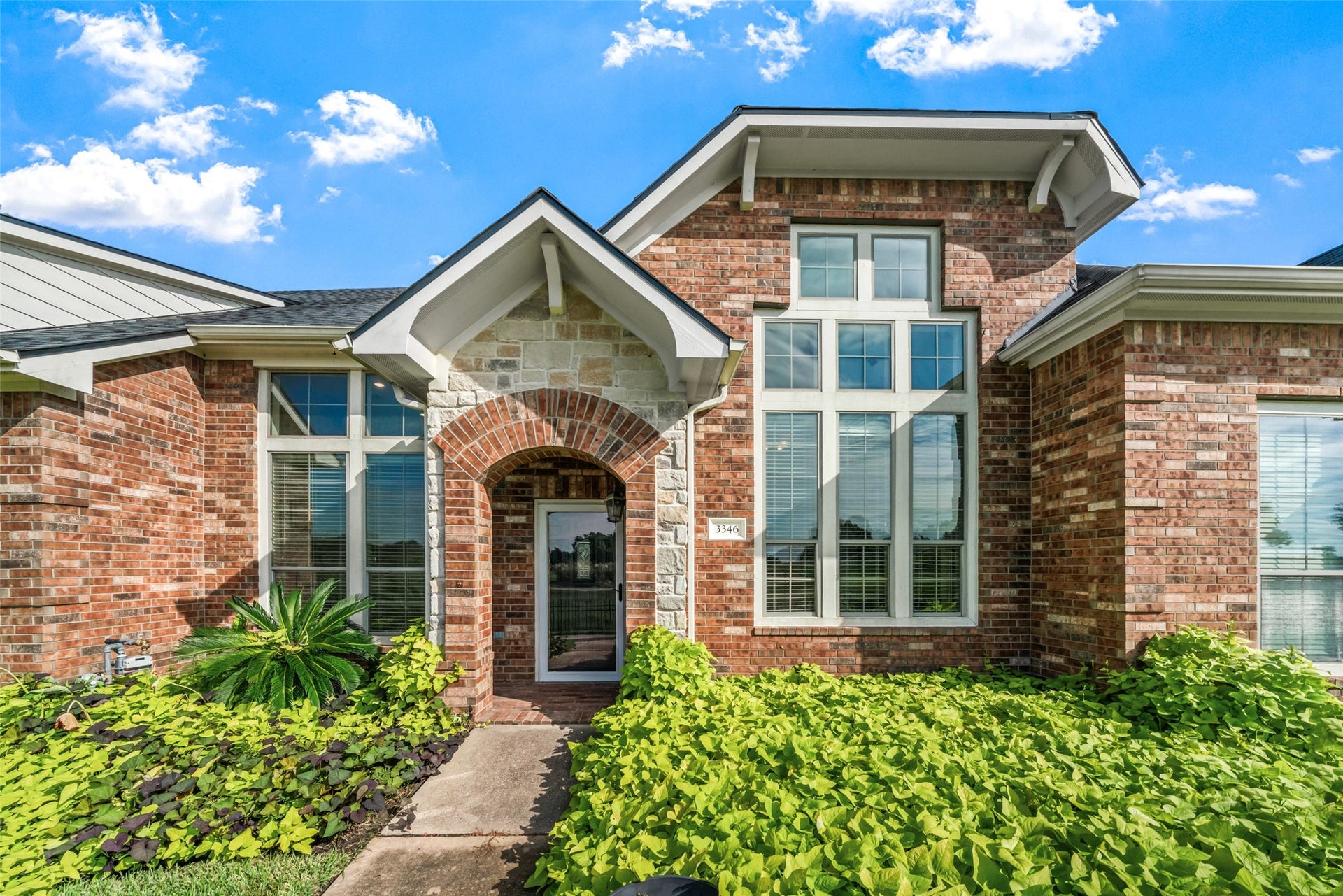 Lovely, covered patio entrance. This two-story townhome is entirely brick.  Notice all of those windows that offer a great view of the golf course!