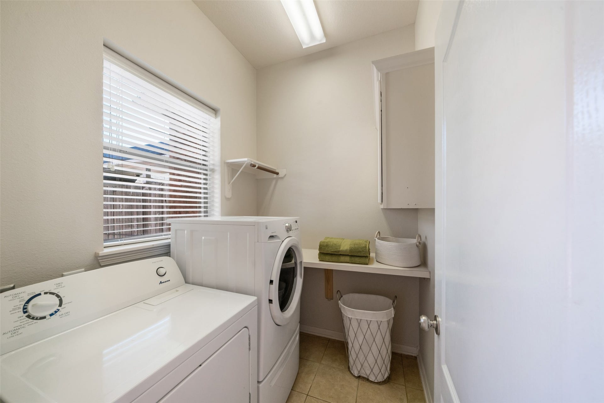 Laundry room on the first floor across from the primary bedroom.