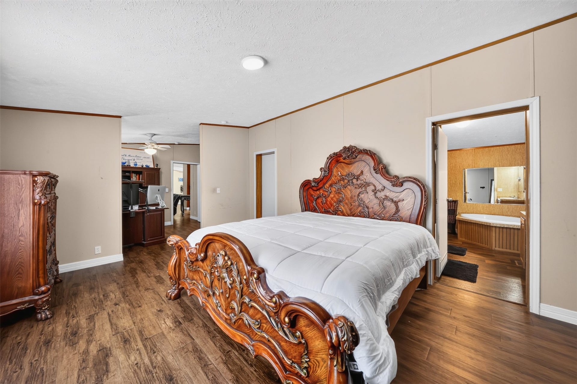 2581 Mann Road, Conroe, TX 77303 Spacious bedroom with wood-look flooring and room for additional furnishings.