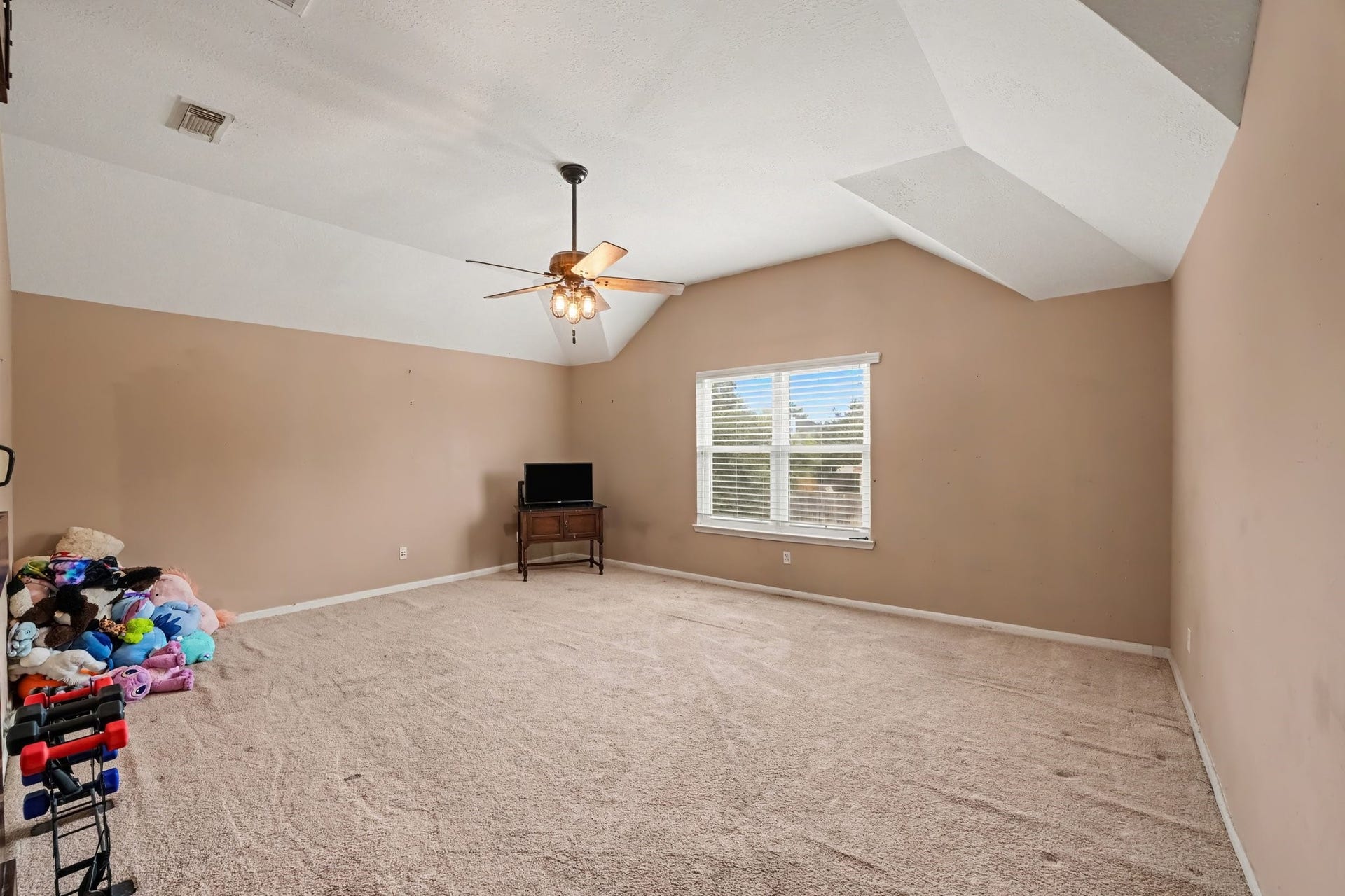 12807 Rocky Briar Lane, Tomball, TX 77377 Another view of the upstairs game room that offers a versatile space for movie nights, games, or simply relaxing, with a vaulted ceiling and natural light.
