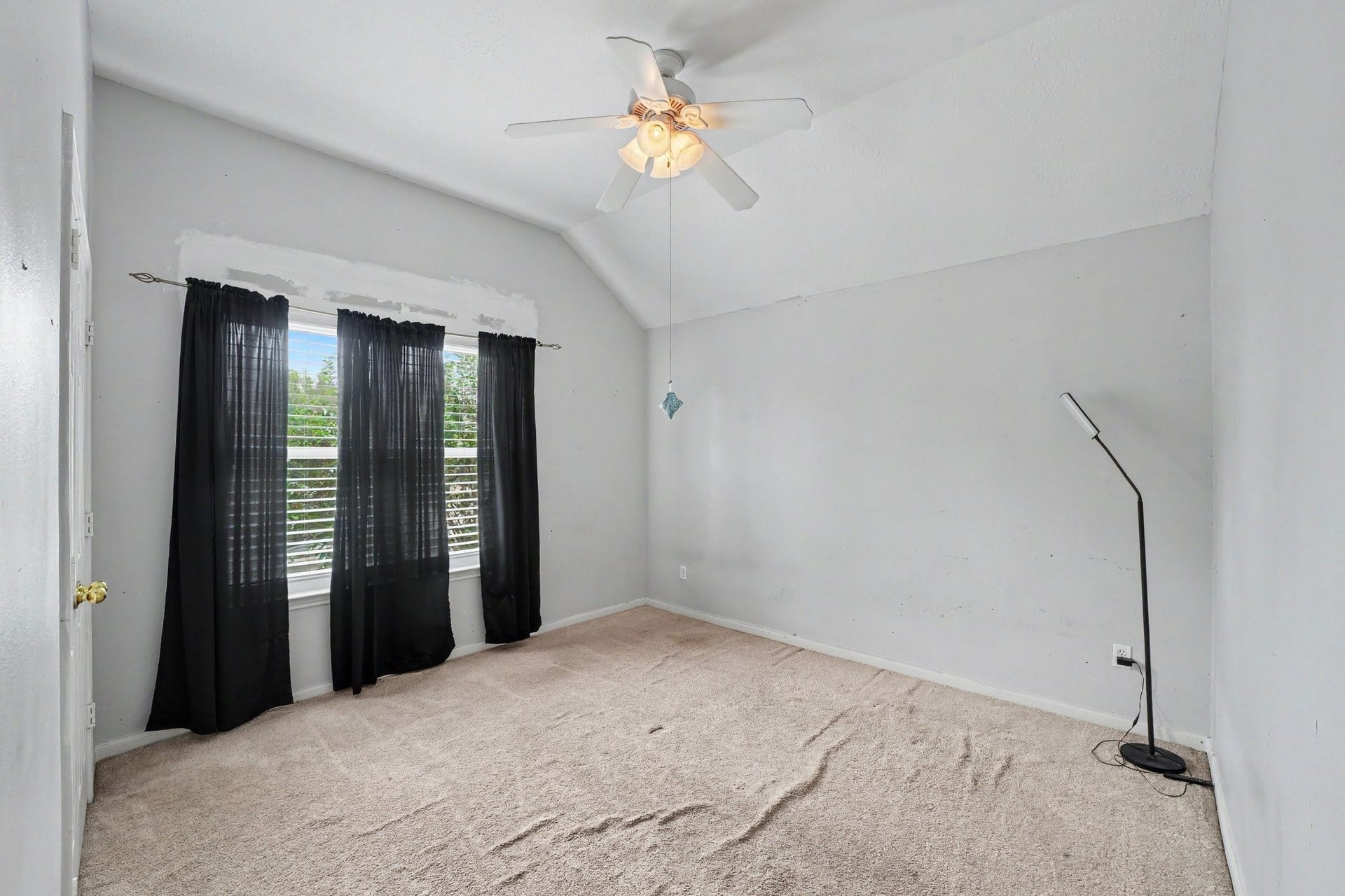 12807 Rocky Briar Lane, Tomball, TX 77377 This secondary bedroom features a vaulted ceiling, ceiling fan, and natural light, offering a comfortable space for family or guests.