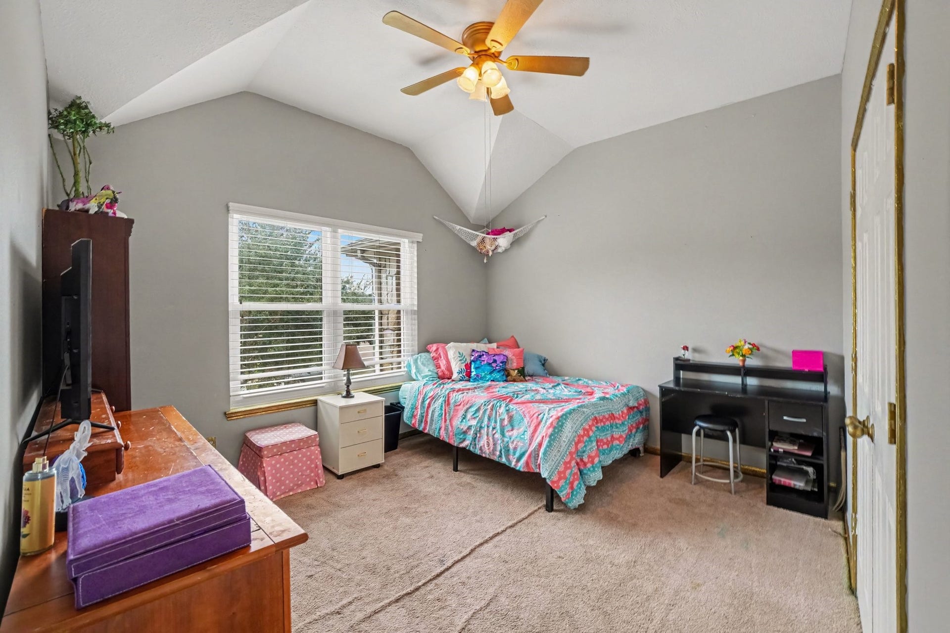 12807 Rocky Briar Lane, Tomball, TX 77377 Another secondary bedroom features a vaulted ceiling, ceiling fan, and a large window that brings in natural light, creating a bright and inviting space.