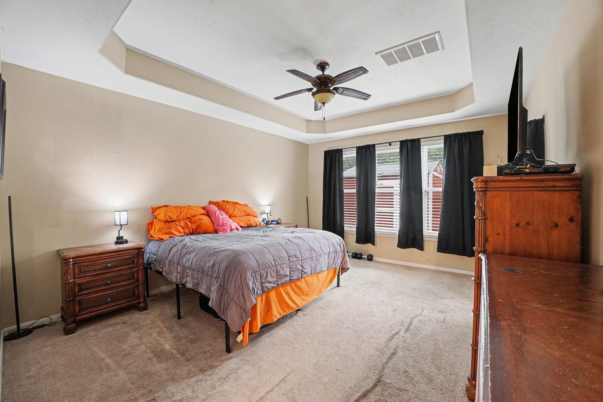 12807 Rocky Briar Lane, Tomball, TX 77377 The primary suite features a beautiful tray ceiling, ceiling fan, and plenty of natural light, creating a comfortable retreat at the end of the day.
