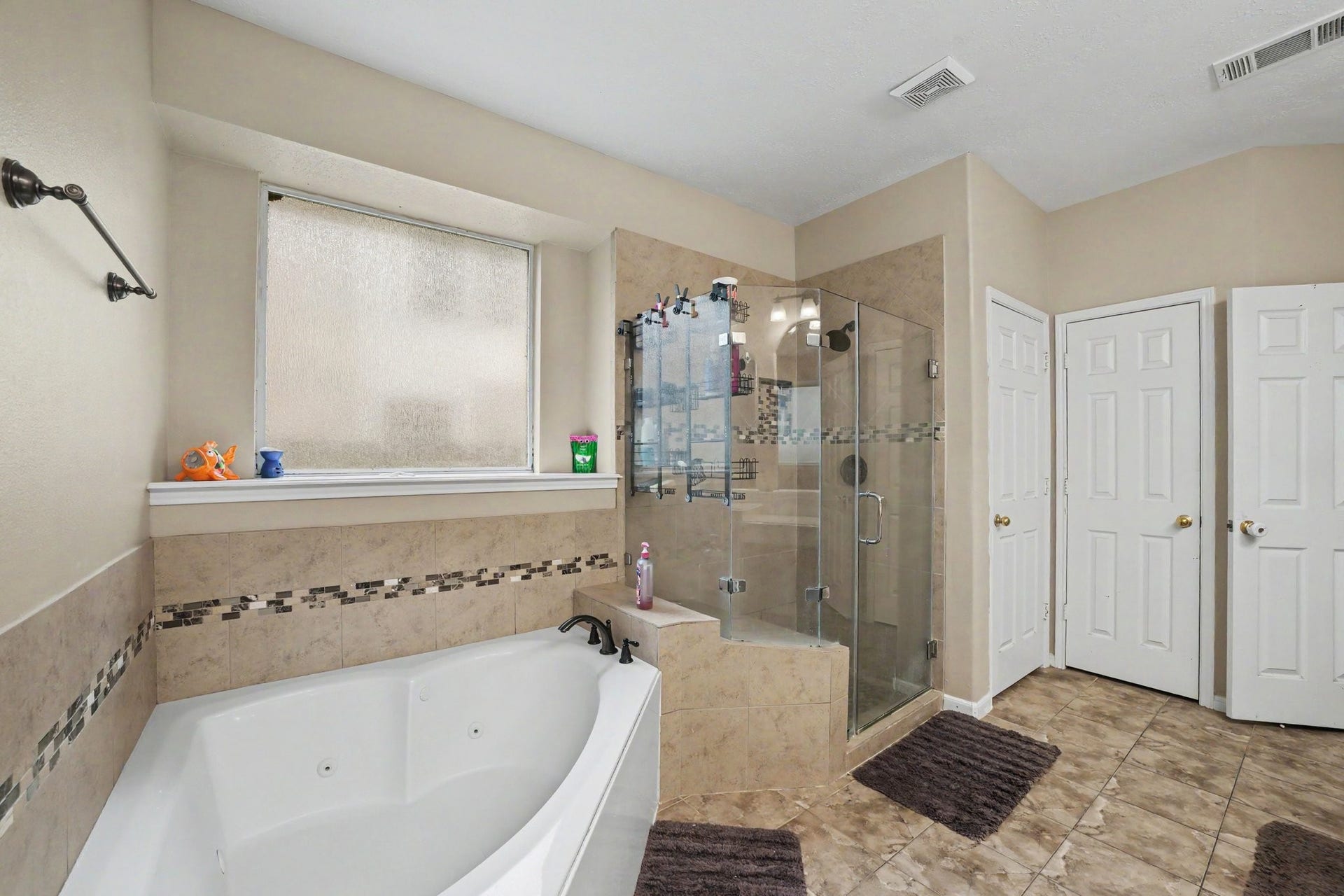 12807 Rocky Briar Lane, Tomball, TX 77377 Another view of the primary bathroom highlights the soaking tub, separate glass-enclosed shower, and convenient access to the walk-in closet.