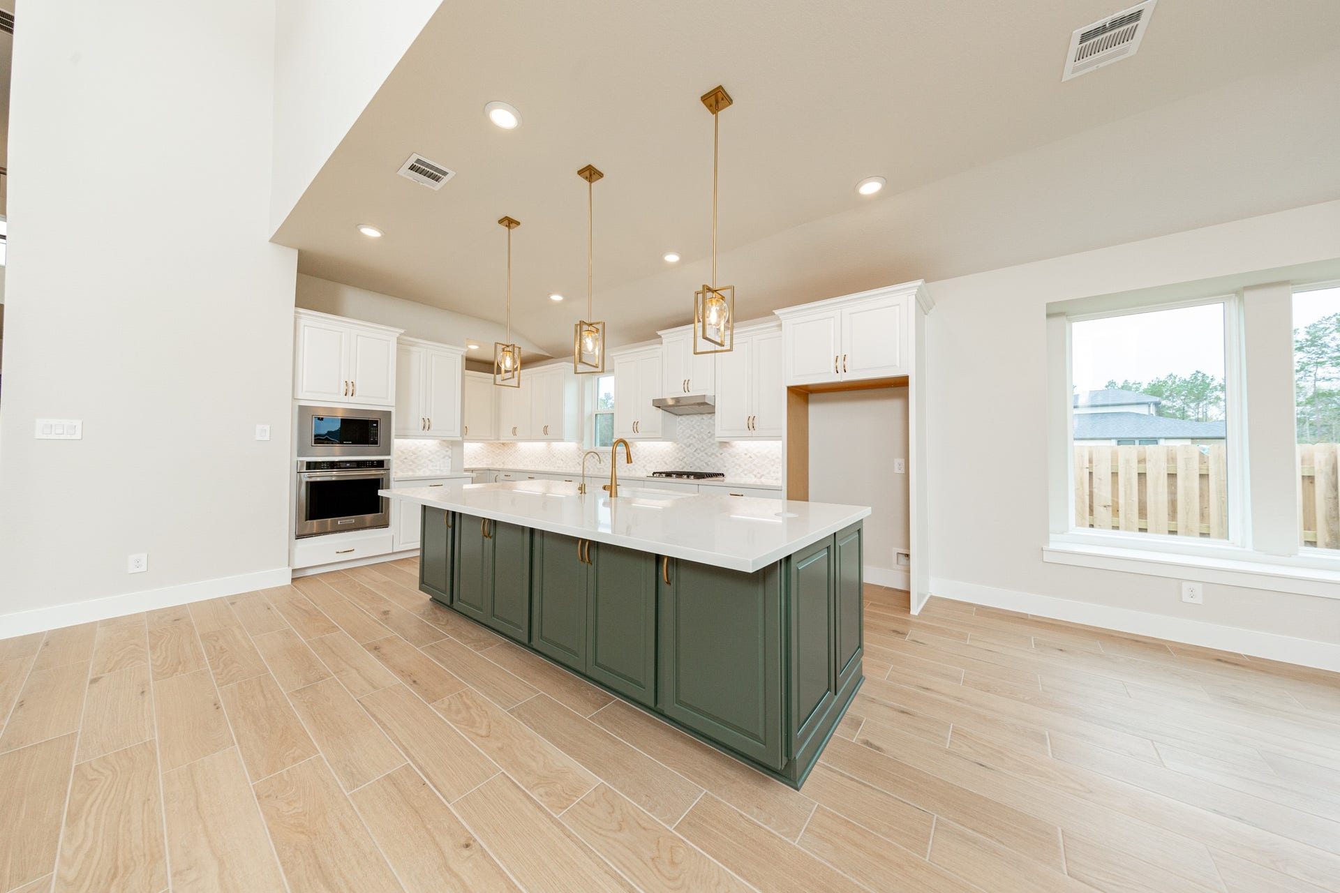 The stunning and generously sized center island features a breakfast bar, perfect for casual dining and entertaining. The island is beautifully designed with pristine quartz countertop and elegant pendant lights.