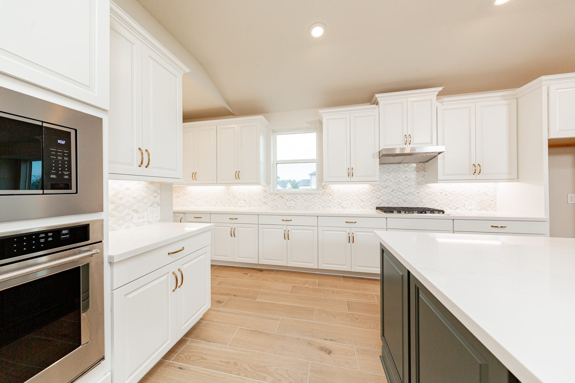 This gourmet, open-concept kitchen is truly the heart of the home, meticulously designed with both aesthetics and functionality in mind. White Shaker-style cabinetry that extends to the ceiling, offering maximum storage space. Quartz countertops, modern backsplash and gold-tones hardware giving it all a touch of luxury.