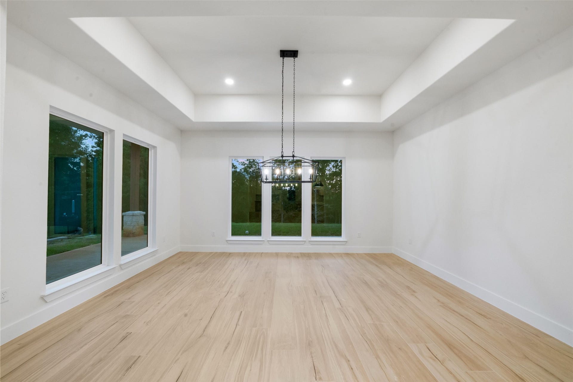 4833 W Fork Boulevard, Conroe, TX 77304 Elegant dining room featuring a beautiful tray ceiling, statement chandelier, and expansive windows overlooking the backyard. Generous proportions provide an exceptional setting for memorable gatherings and formal entertaining.