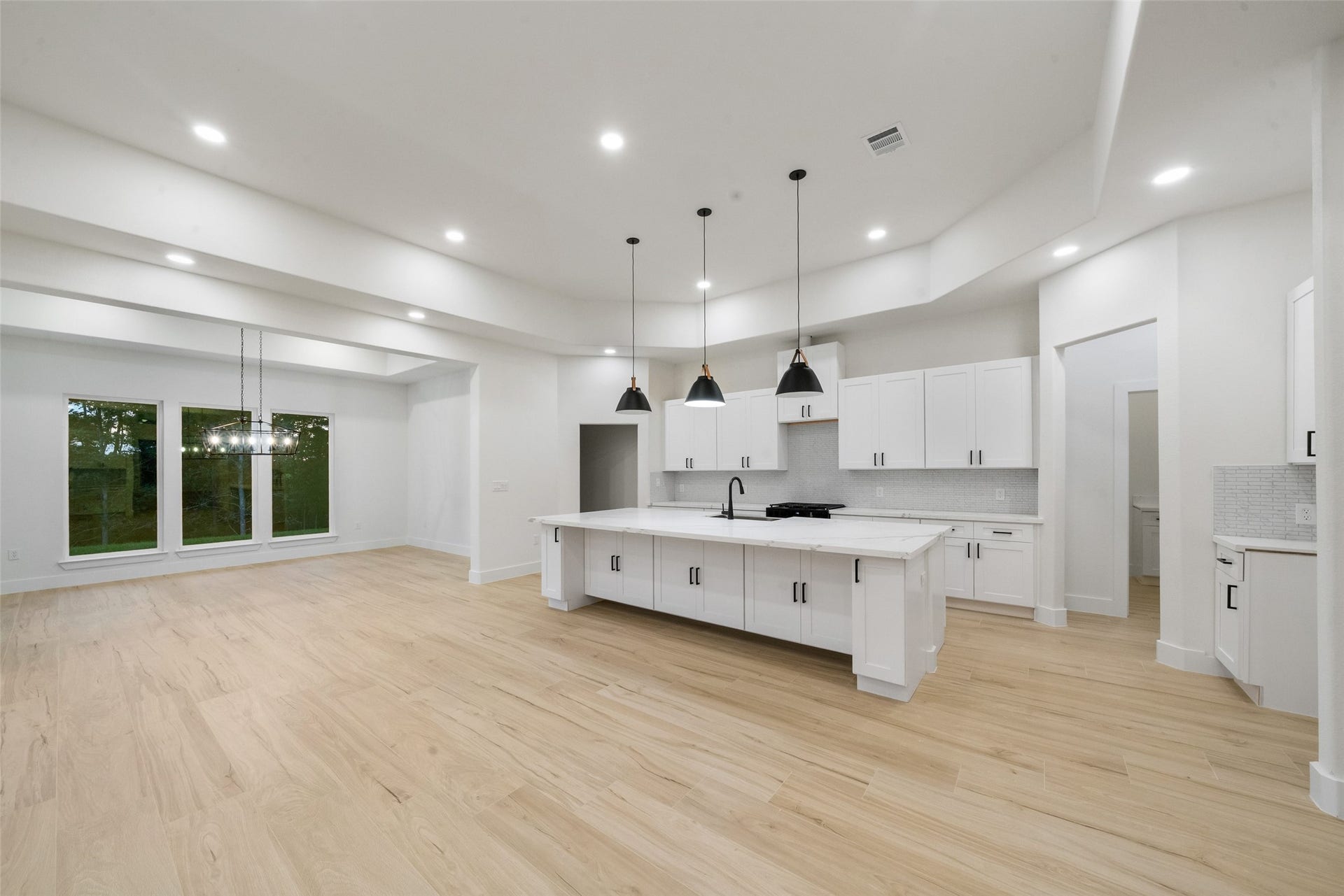 4833 W Fork Boulevard, Conroe, TX 77304 Expansive living and dining spaces beautifully complement the gourmet kitchen, creating a sophisticated setting for everyday living and entertaining. Large windows invite natural light while highlighting the home's elegant finishes and thoughtful design.