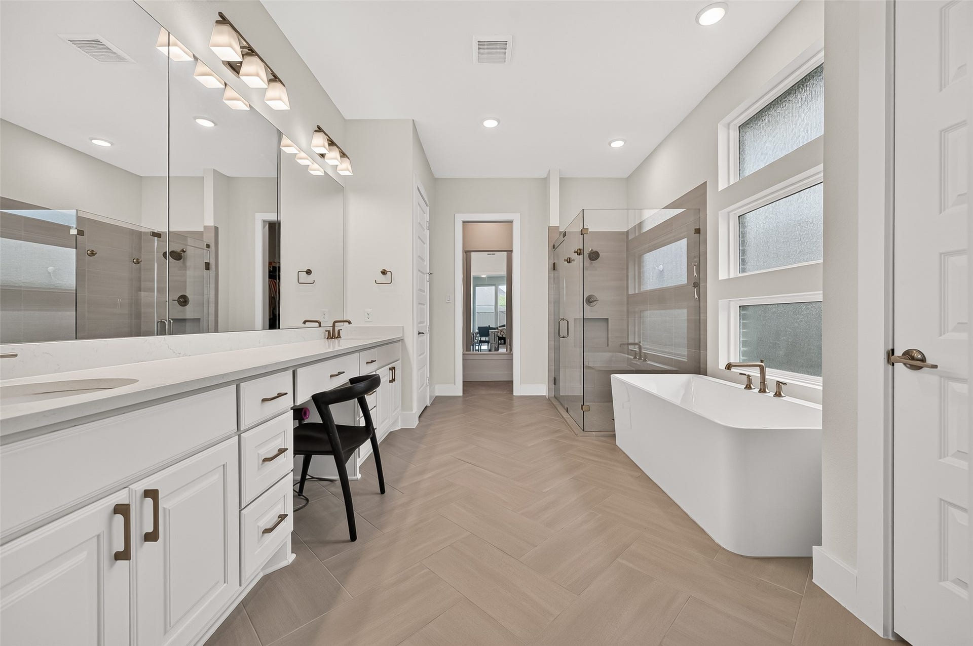 2710 Berry Basket Trail, Richmond, TX 77406 The primary bath offers double vanities, abundant countertop and storage space, a huge soaking tub, an oversized glass-enclosed walk-in shower with bench, and a large primary closet.