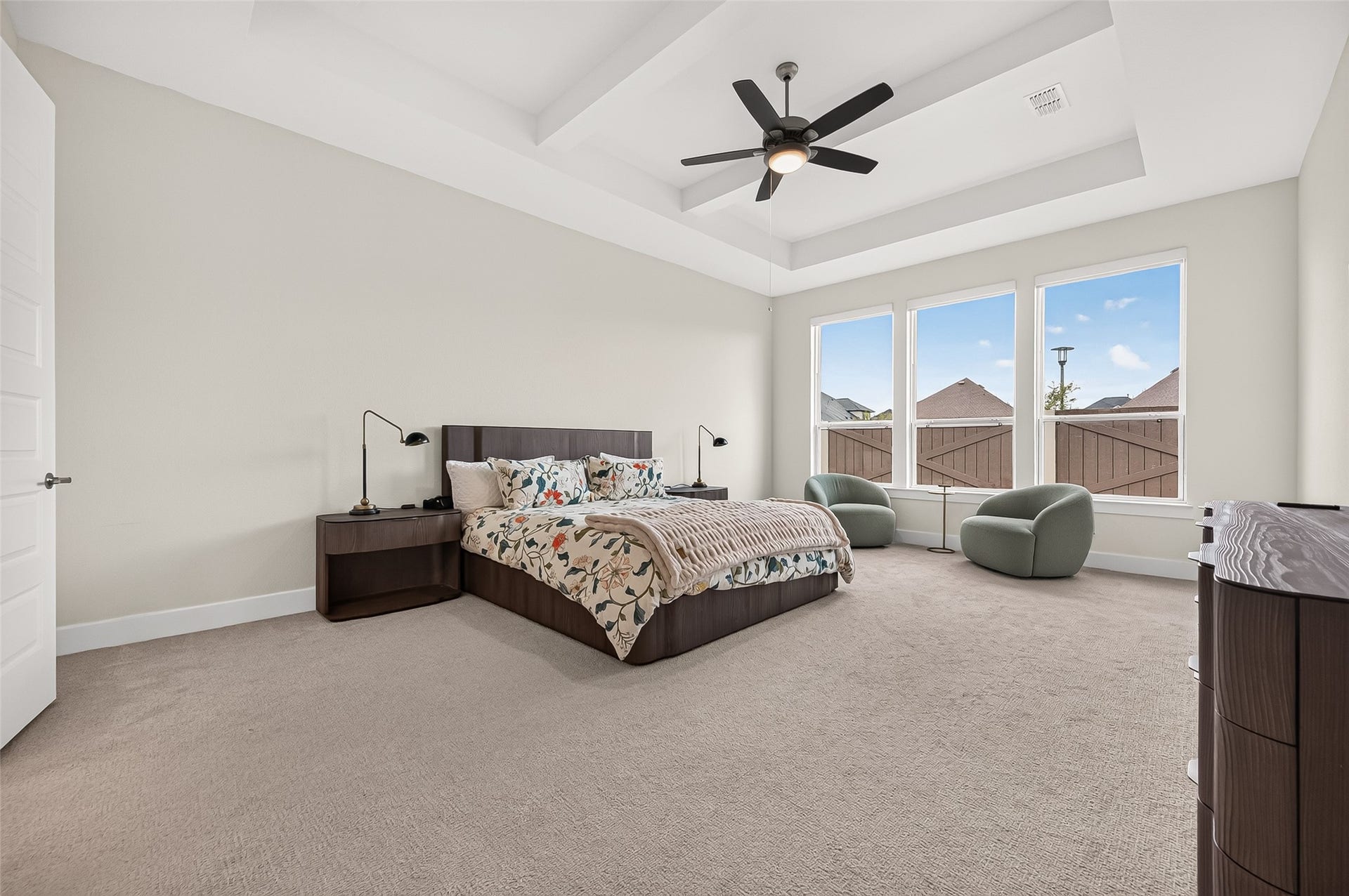 2710 Berry Basket Trail, Richmond, TX 77406 The luxurious primary suite is located downstairs and features high ceilings with a beautiful beam/coffered ceiling detail and a wall of windows.