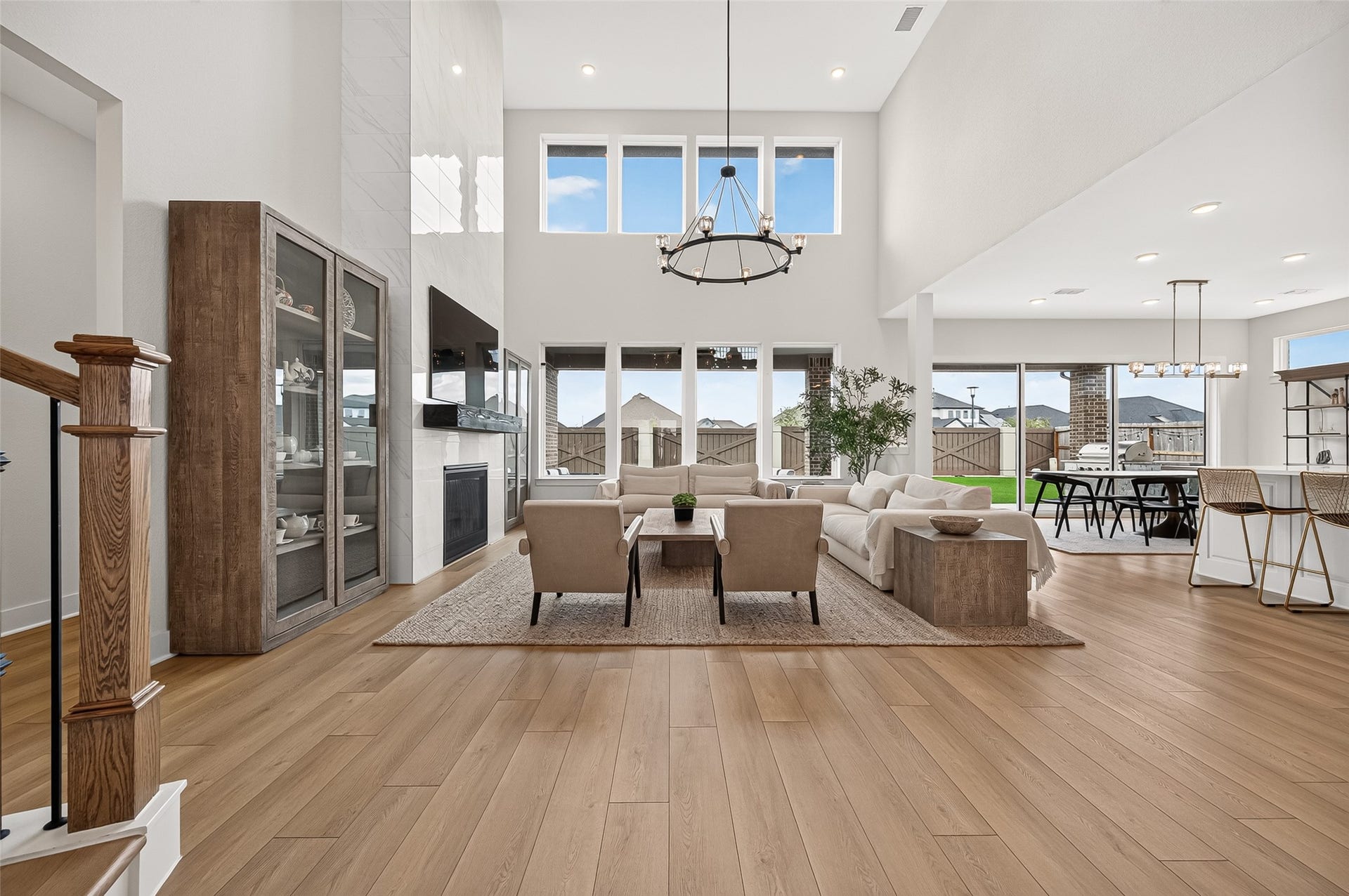2710 Berry Basket Trail, Richmond, TX 77406 The open-concept family room showcases soaring ceilings, a wall of windows providing abundant natural light, and a dramatic floor-to-ceiling tiled fireplace.