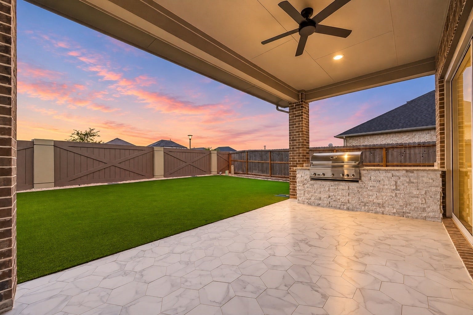 2710 Berry Basket Trail, Richmond, TX 77406 The outdoor living space is equally impressive, featuring a large covered patio with tiled pavers, outdoor kitchen, extensive seating area, fully turfed backyard, and no rear neighbors.