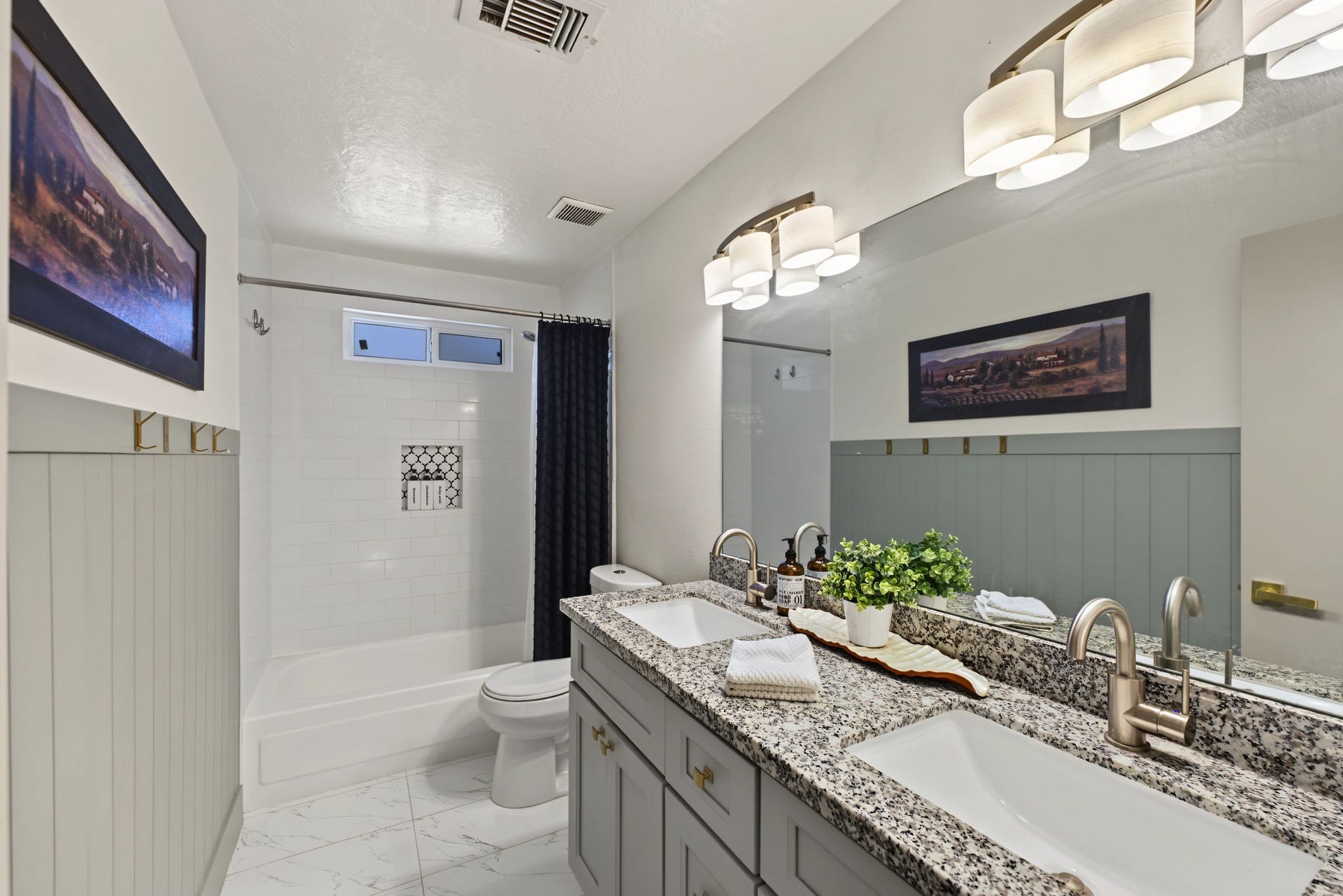 5006 Deer Point Drive, Spring, TX 77389 Secondary bath features a granite double vanity, subway tile tub/shower with decorative niche and marble-look tile floors!