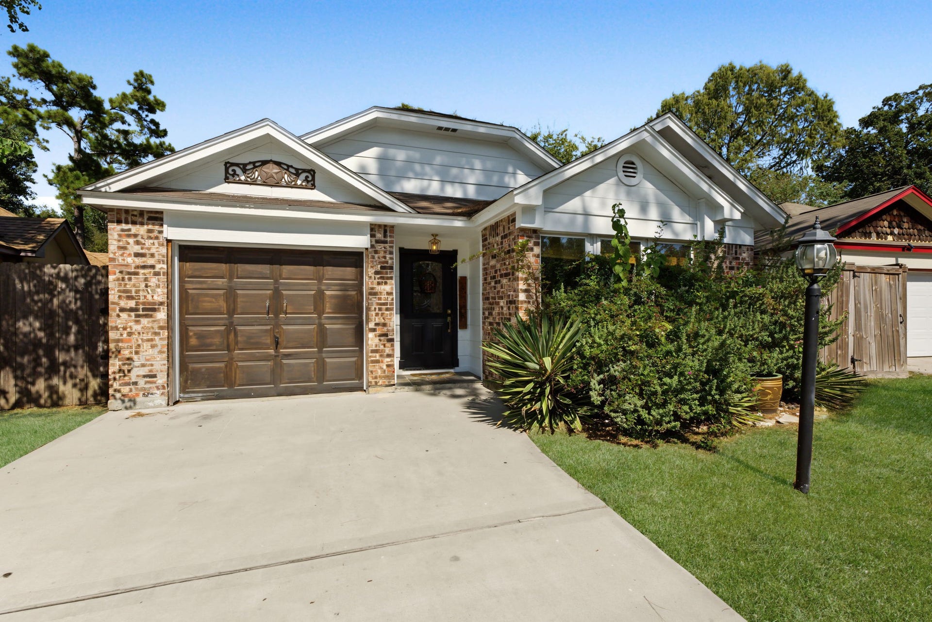 5006 Deer Point Drive, Spring, TX 77389 Inviting curb appeal with a decorative Texas star gable accent and wood-tone garage door.
