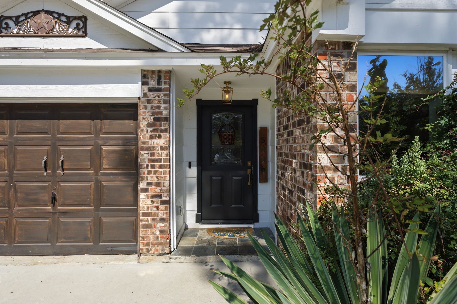 5006 Deer Point Drive, Spring, TX 77389 Welcoming entry features a black front door with leaded glass, slate tile stoop and lantern lighting.