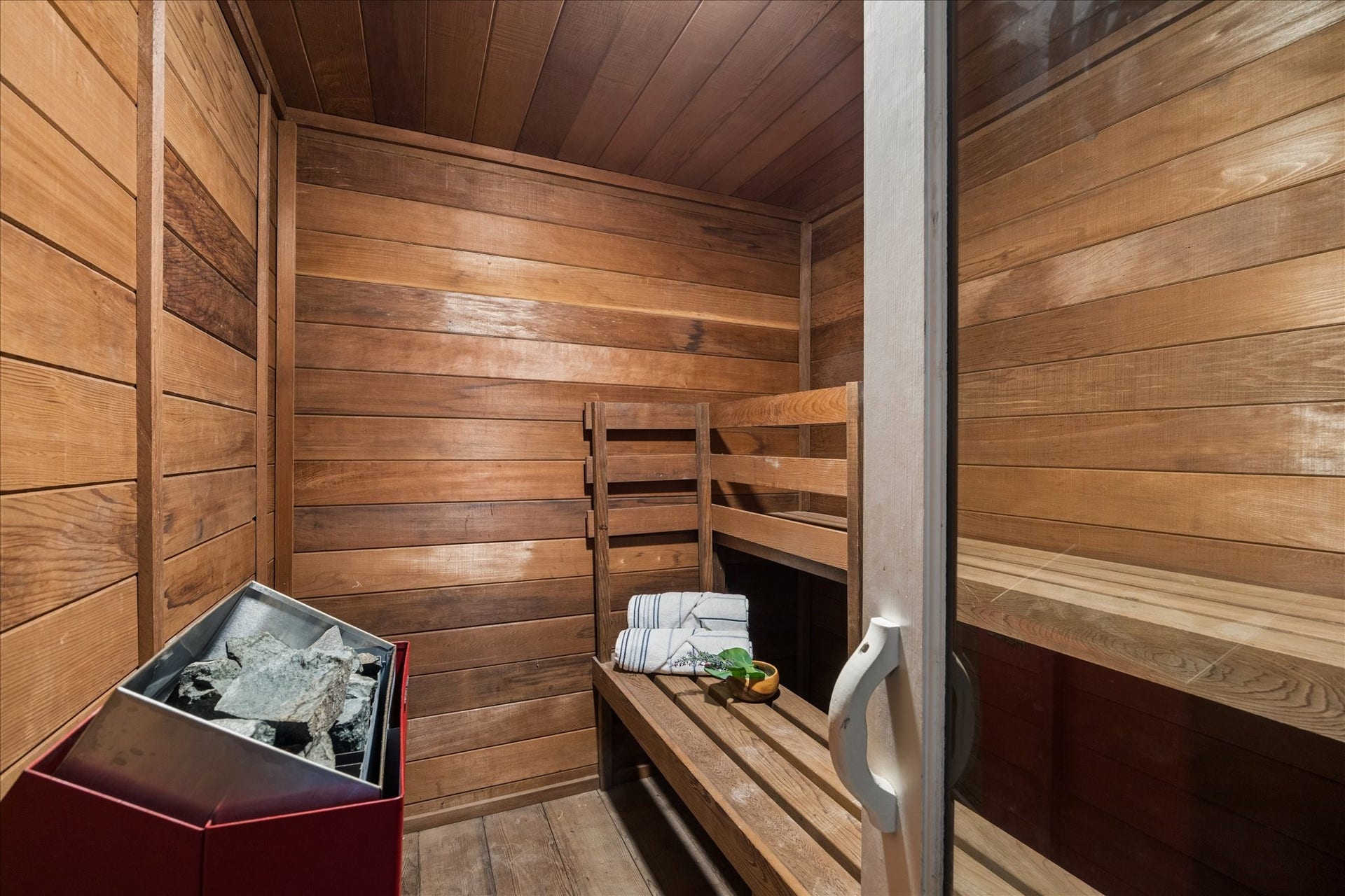 2411 Oakbank Drive, Kingwood, TX 77339 Your very own wood-paneled sauna with a bench and a rock heater, perfect for relaxation and wellness at home.