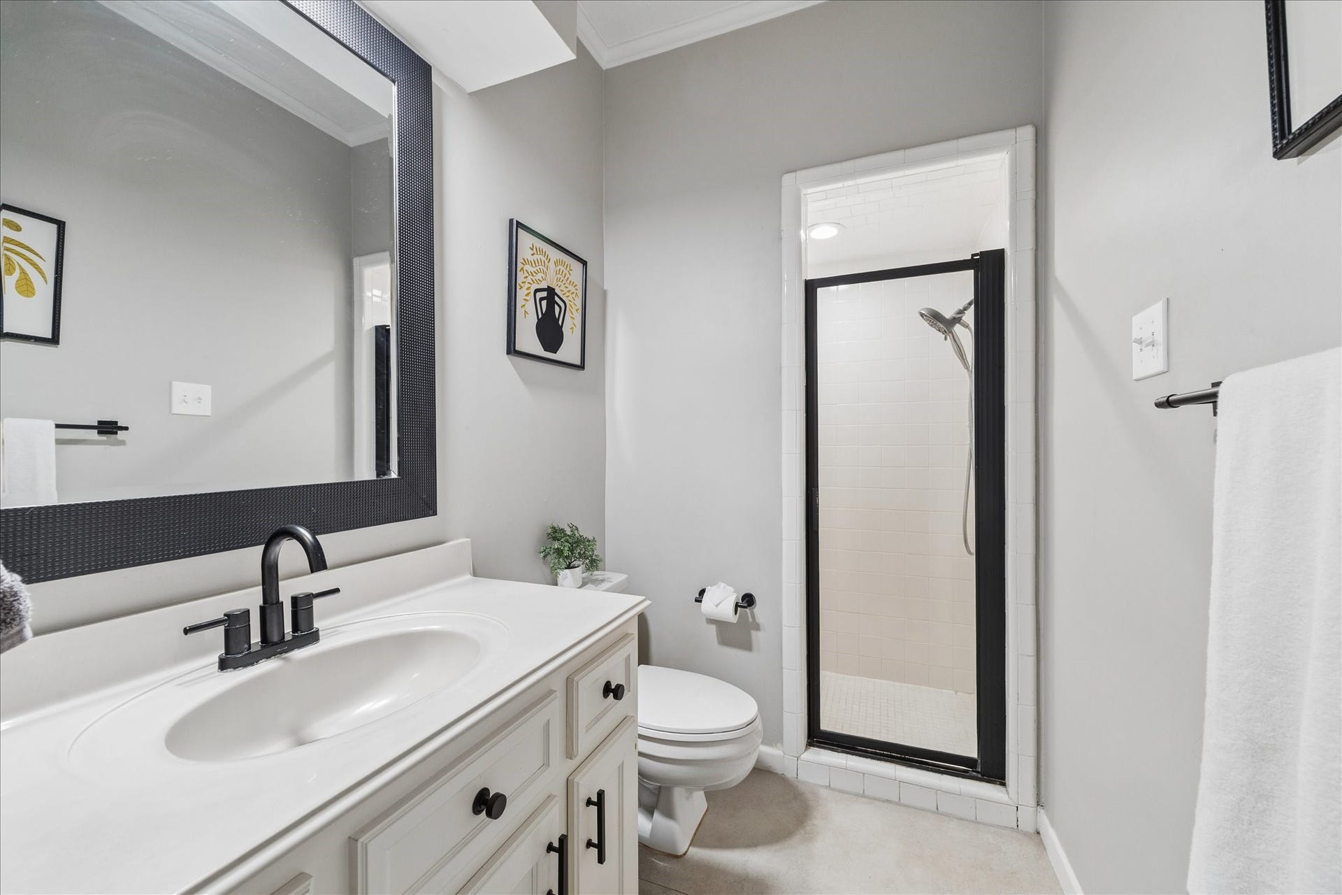 2411 Oakbank Drive, Kingwood, TX 77339 This bathroom is adjacent to the guest bedroom and features a sleek design with a modern vanity, a large framed mirror, and a walk-in shower with a glass door. Neutral tones create a clean, inviting atmosphere.