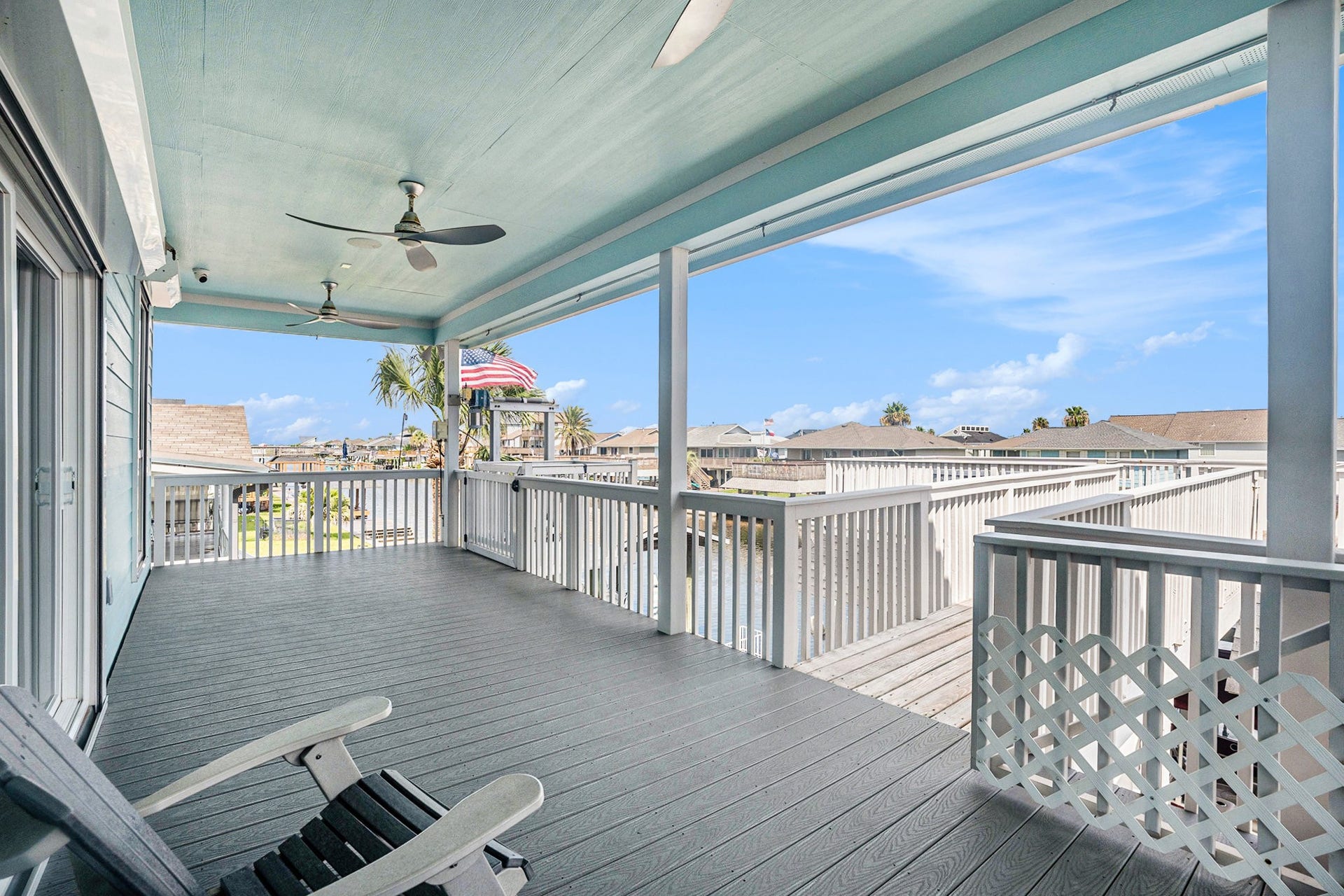 1171 Sailfish Street, Bayou Vista, TX 77563 Spacious covered deck with ceiling fans, offering serene views of the surrounding neighborhood and canal. Perfect for relaxing and enjoying the coastal breeze.
