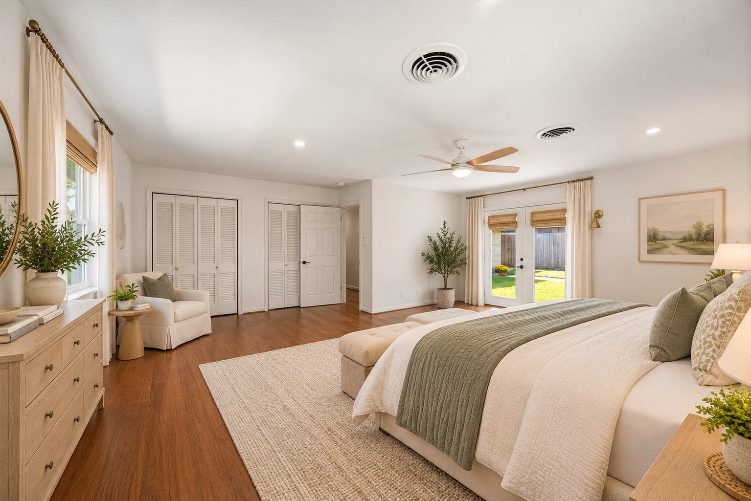 4806 Hummingbird Street, Houston, TX 77035 Spacious and bright bedroom with elegant wood flooring, featuring large windows and French doors that open to a lush backyard. Cozy seating area and ample closet space enhance functionality. Virtually staged