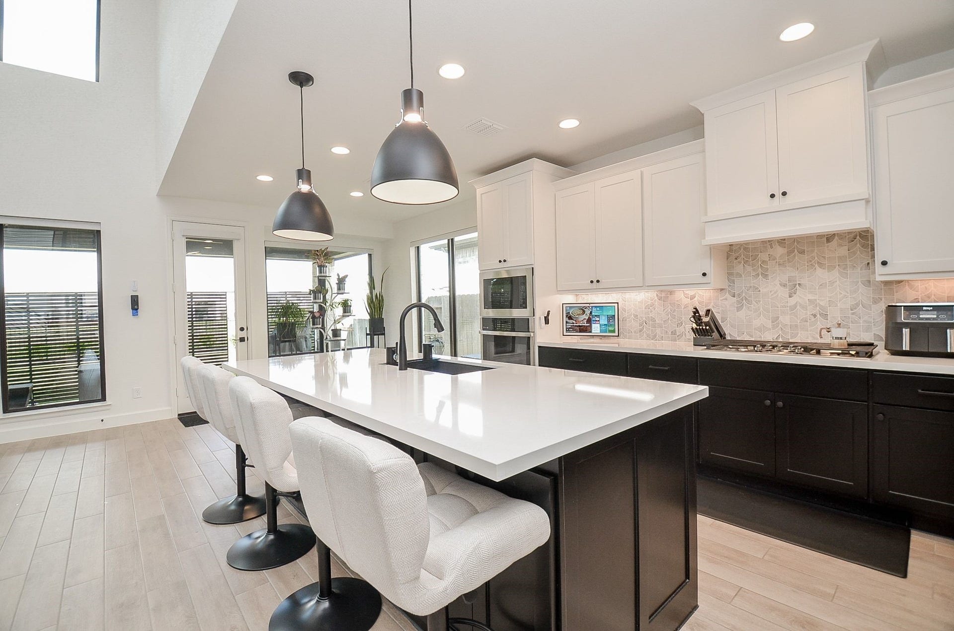 Showstopping kitchen with oversized island, designer lighting, and beautiful cabinetry.