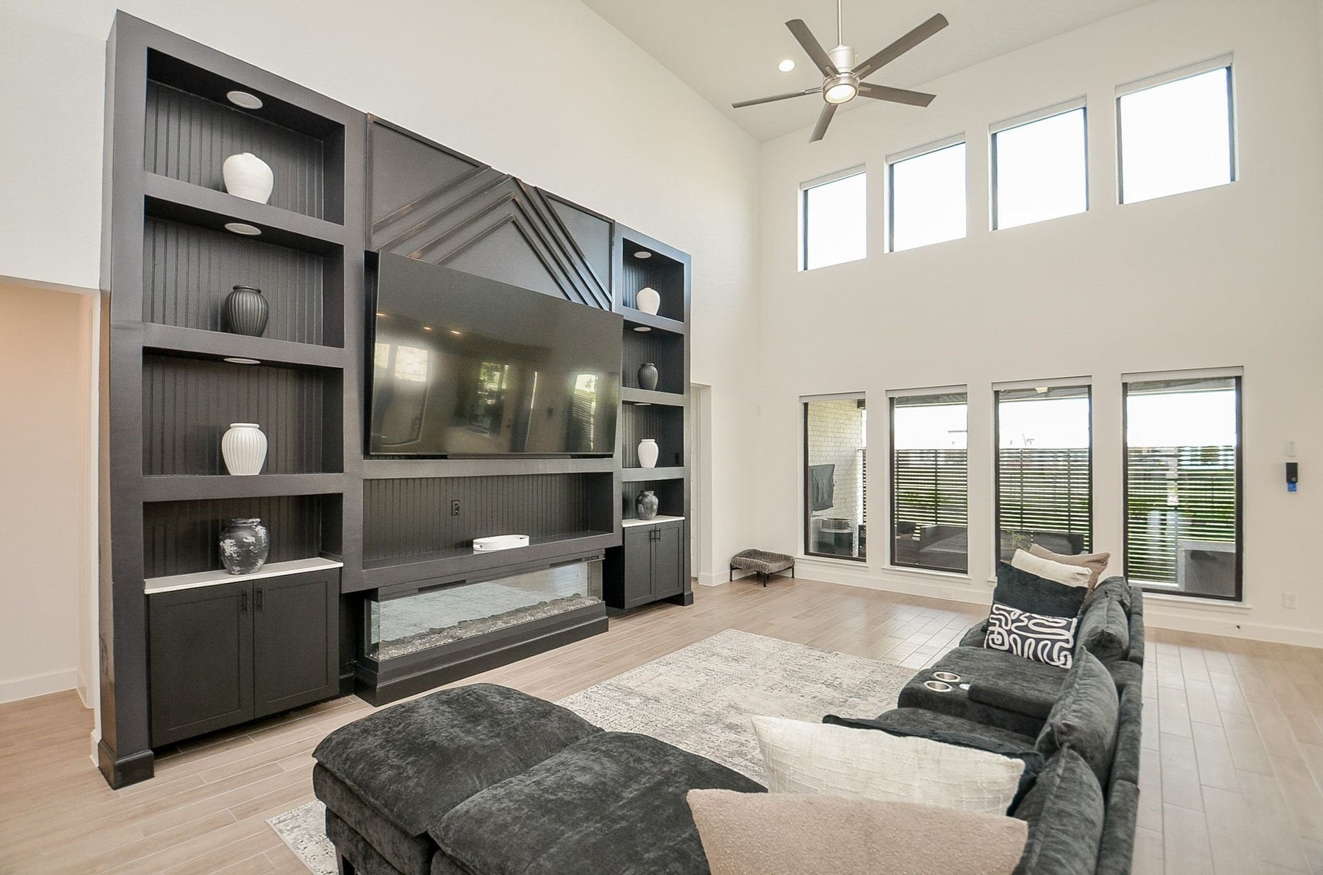 Spectacular two-story family room featuring custom built-ins and a dramatic fireplace wall.
