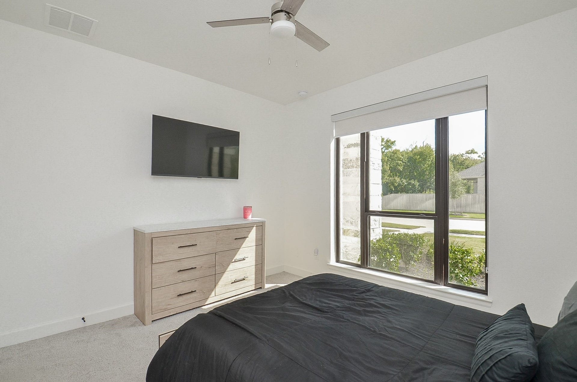 Additional view of the secondary bedroom, featuring ample space and a large window.