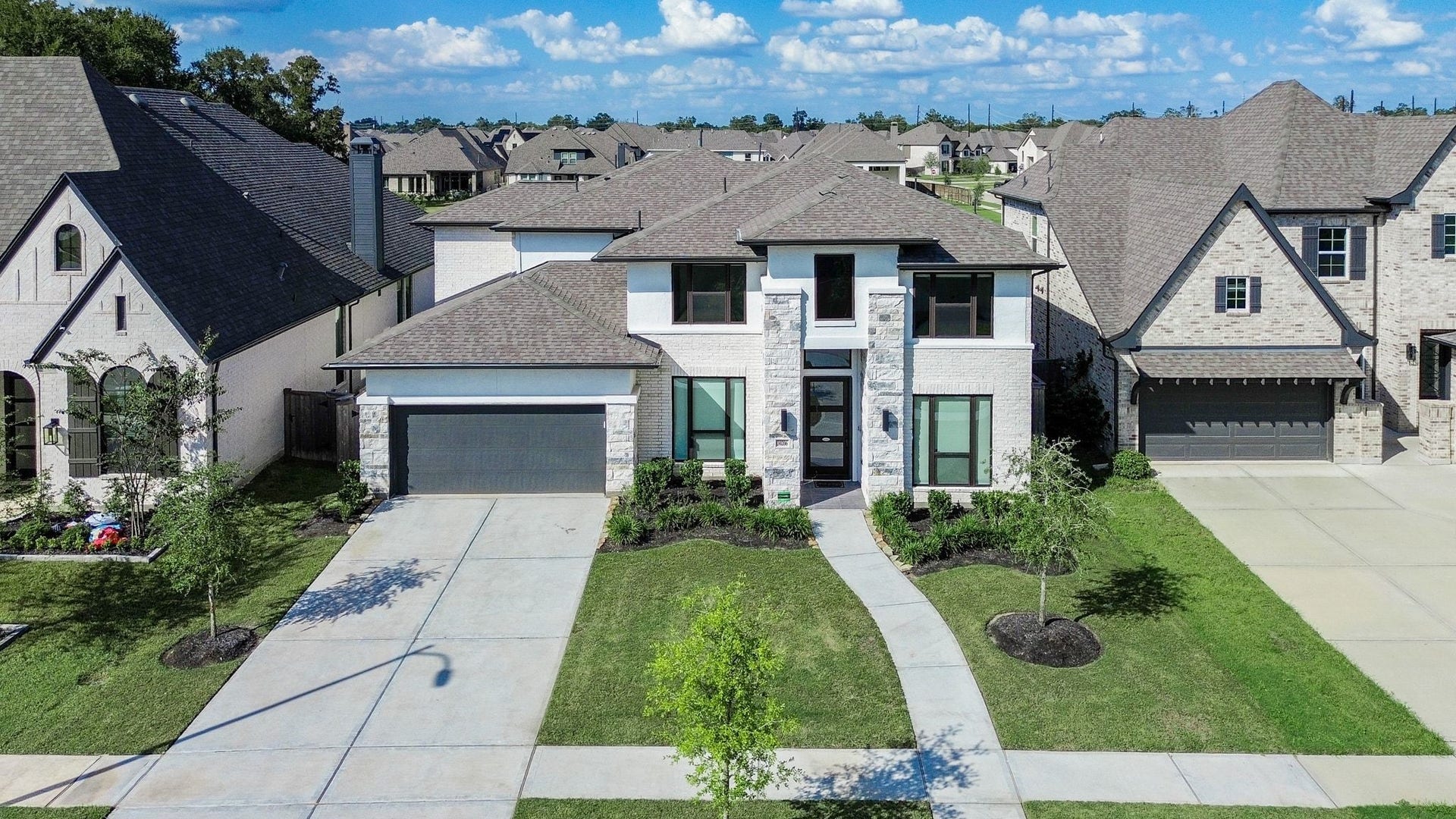 Impressive curb appeal with striking architectural lines and elegant stone accents.