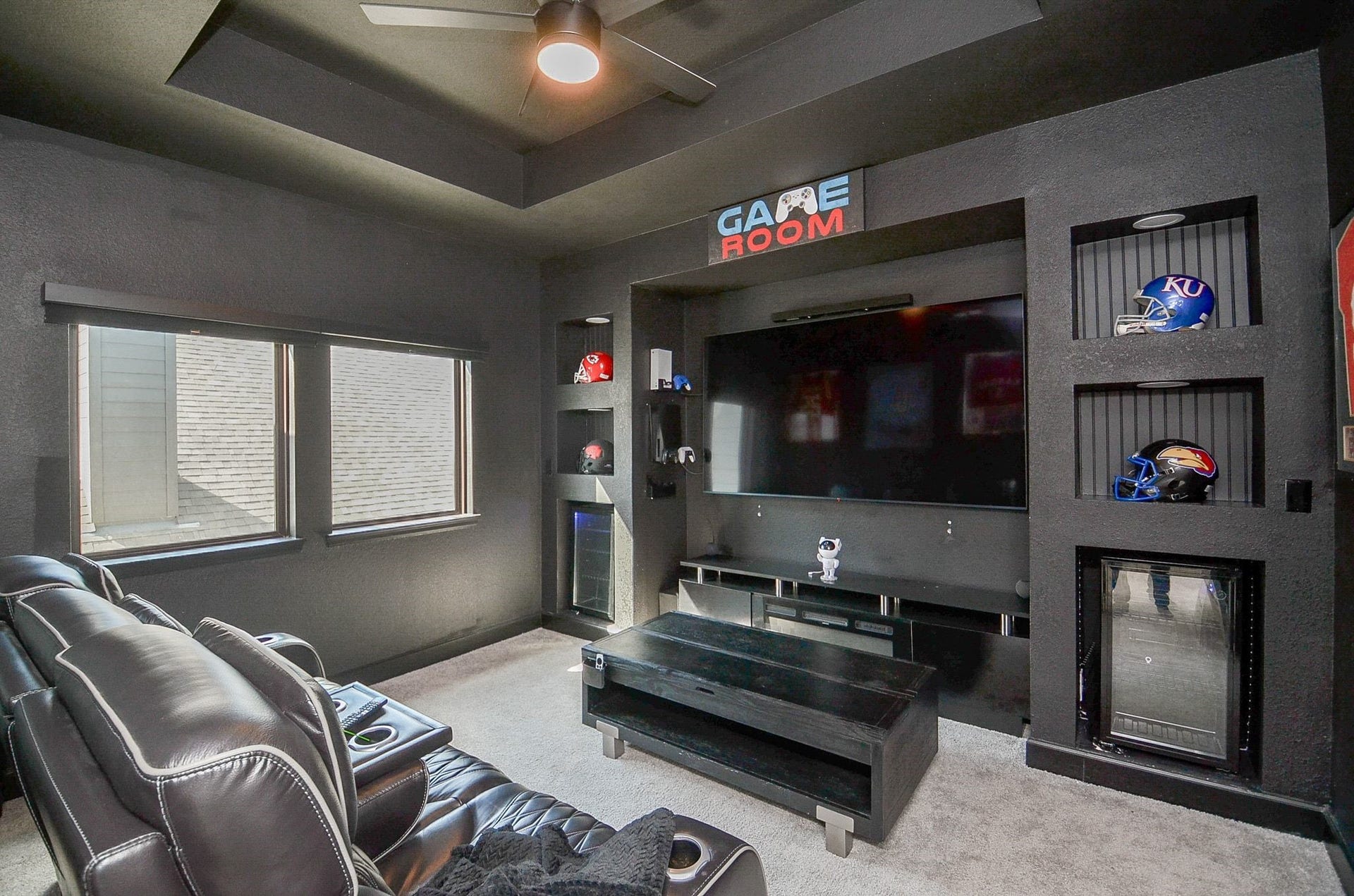 Custom-designed game room featuring built-in entertainment center, display niches, and beverage refrigerators. TV is included.