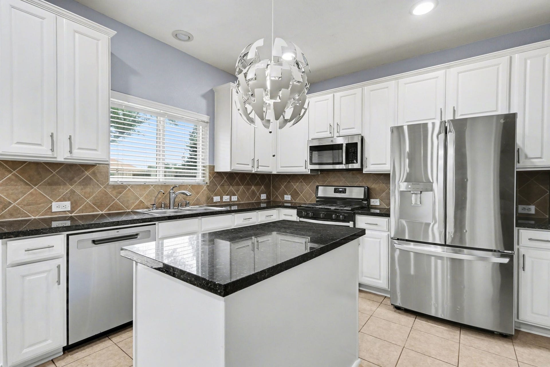 2705 Golden Creek Lane, Pearland, TX 77584 The chef of the home will love this island kitchen! Timeless, crisp white cabinets provides plenty of storage, and granite countertops offers ample prep space! And the showstopping pendant light just sparkles!