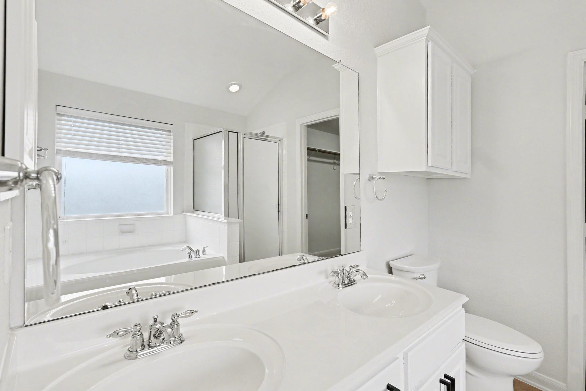2705 Golden Creek Lane, Pearland, TX 77584 This primary ensuite bath is spa-like featuring a dual sink vanity with drawers and cabinets for storage, and a cabinet above the commode for additional things!