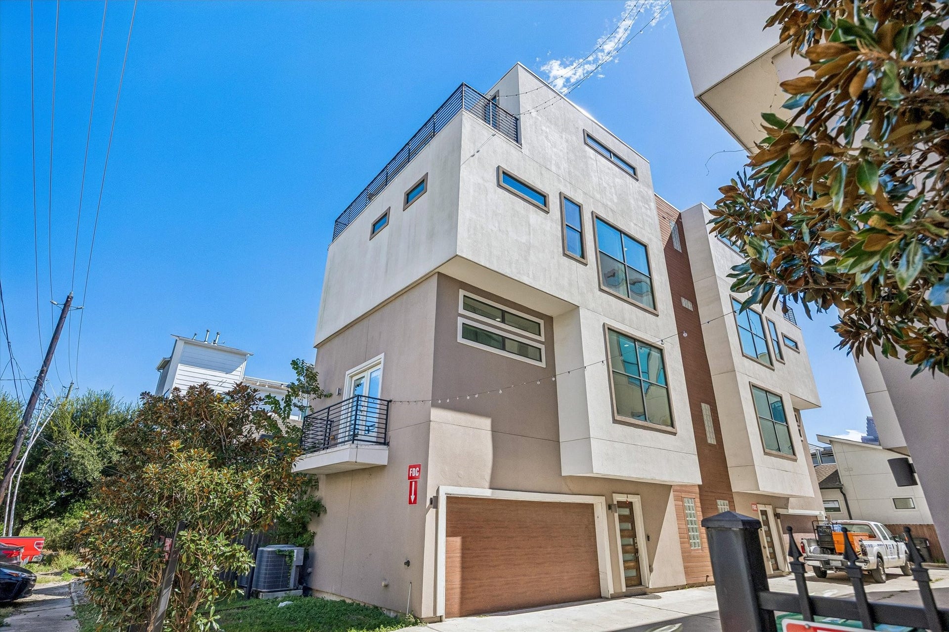 1215 Summer Street, #A, Houston, TX 77007 Angled exterior view highlighting the homes multiple levels, distinctive window placement, side balcony, and rooftop terrace.